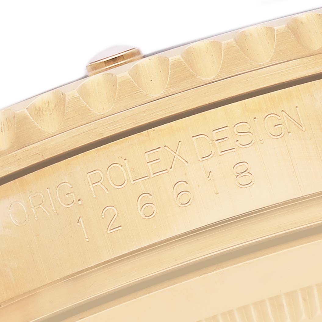 The image shows a close-up of the engraved edge of a Rolex Submariner 126618LB Men's Yellow Gold Blue Dial, displaying part of the case and engraved text.