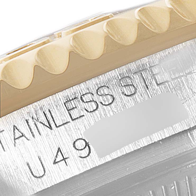 This close-up image of a Rolex Yacht-Master 68623 Men
s Steel and Gold (two tone) White Dial 68623 Men
s Steel and Gold (two tone) White Dial watch shows part of the grooved bezel and the engraved stainless steel case.