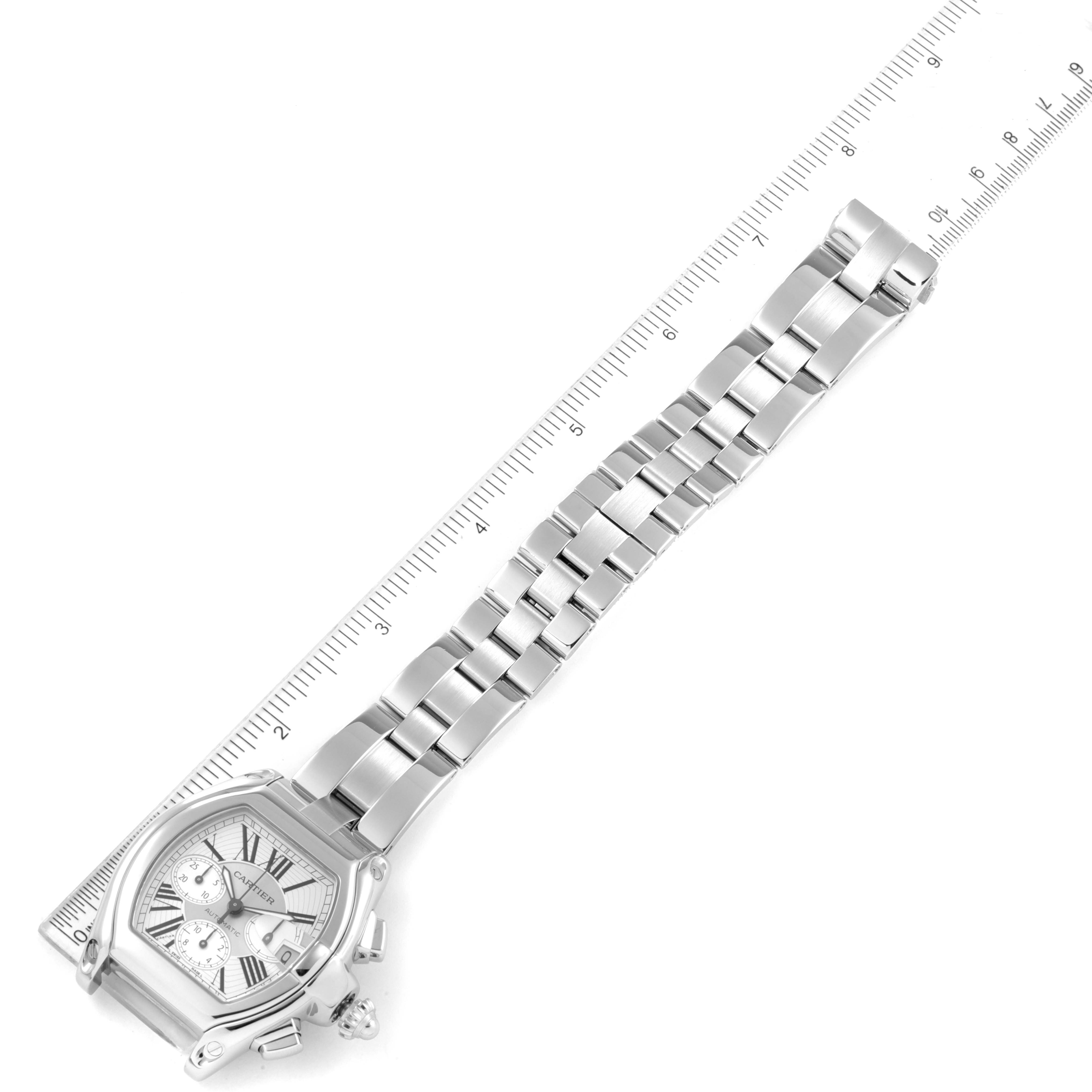 This image shows a top-down view of the Cartier Roadster W62019X6 Men
s Stainless Steel Silver Dial W62019X6 Men
s Stainless Steel Silver Dial watch, including the dial, bracelet, and a ruler for scale.