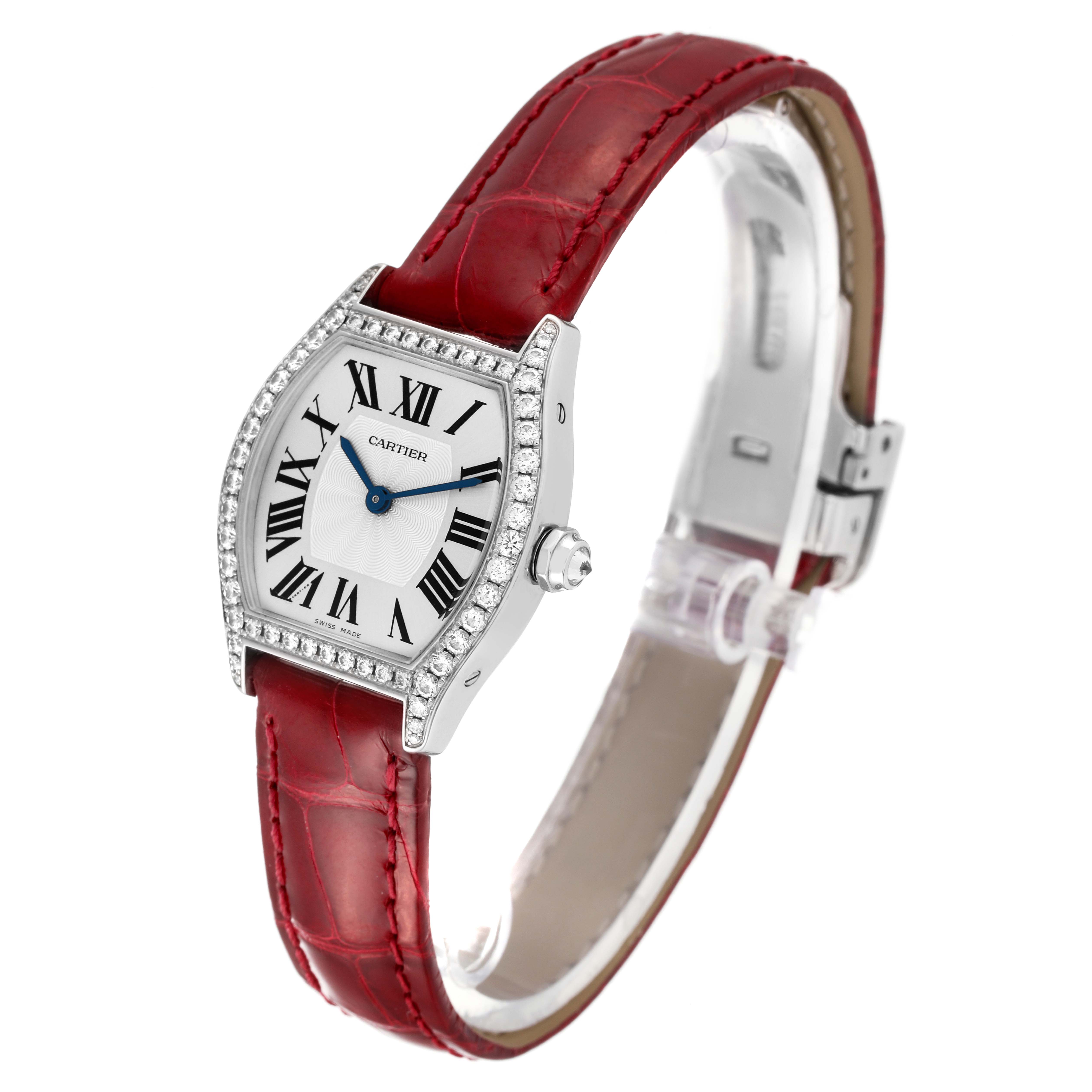 The Cartier Tortue WA501007 Women's White Gold Silver Dial watch is shown at a three-quarter angle, highlighting the red strap, Roman numeral dial, and diamond-set bezel.