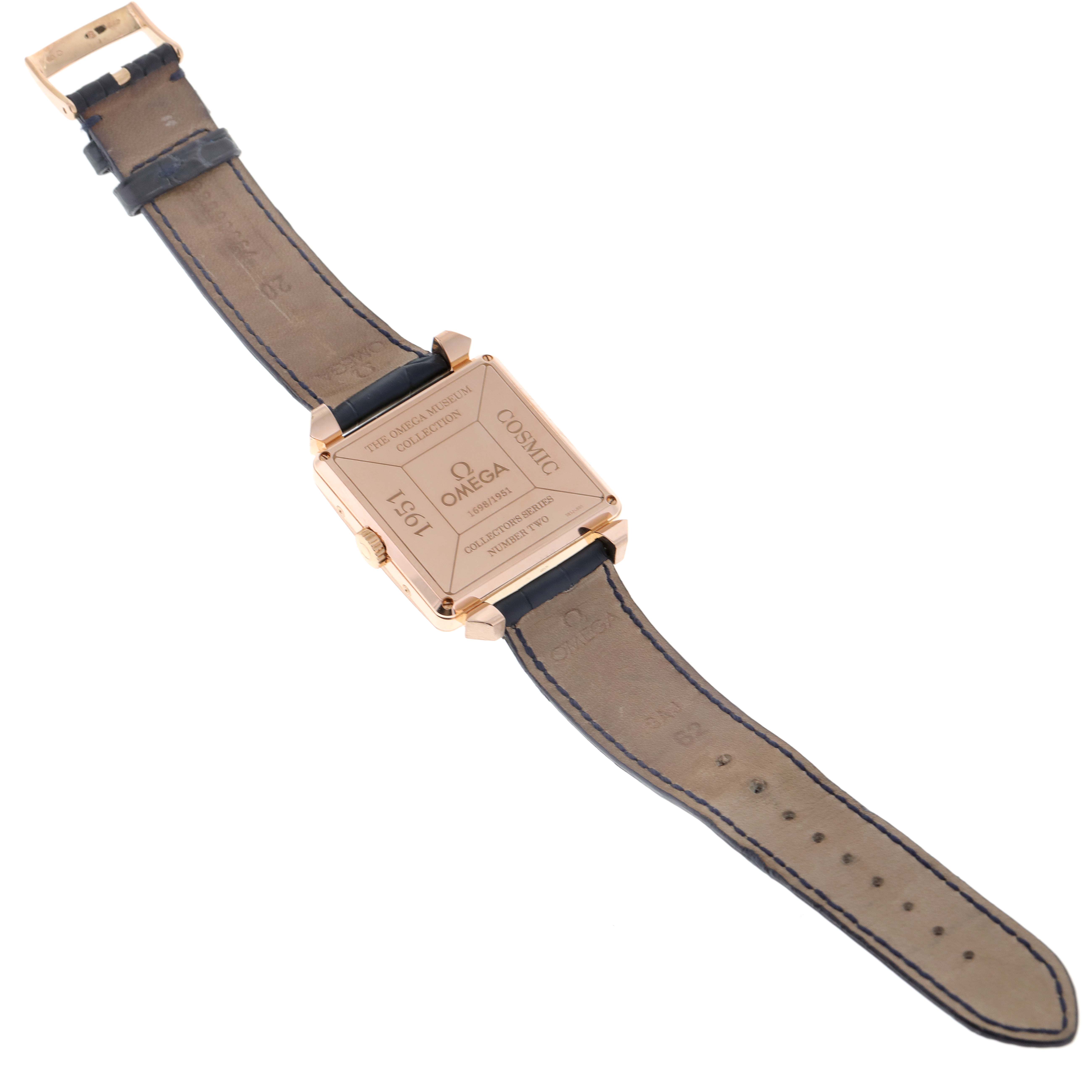 The image shows the back and strap of an Omega Museum 5701.80.03 Men's Rose Gold Blue Dial 5701.80.03 Men's Rose Gold Blue Dial model watch, displaying its engravings and leather band.