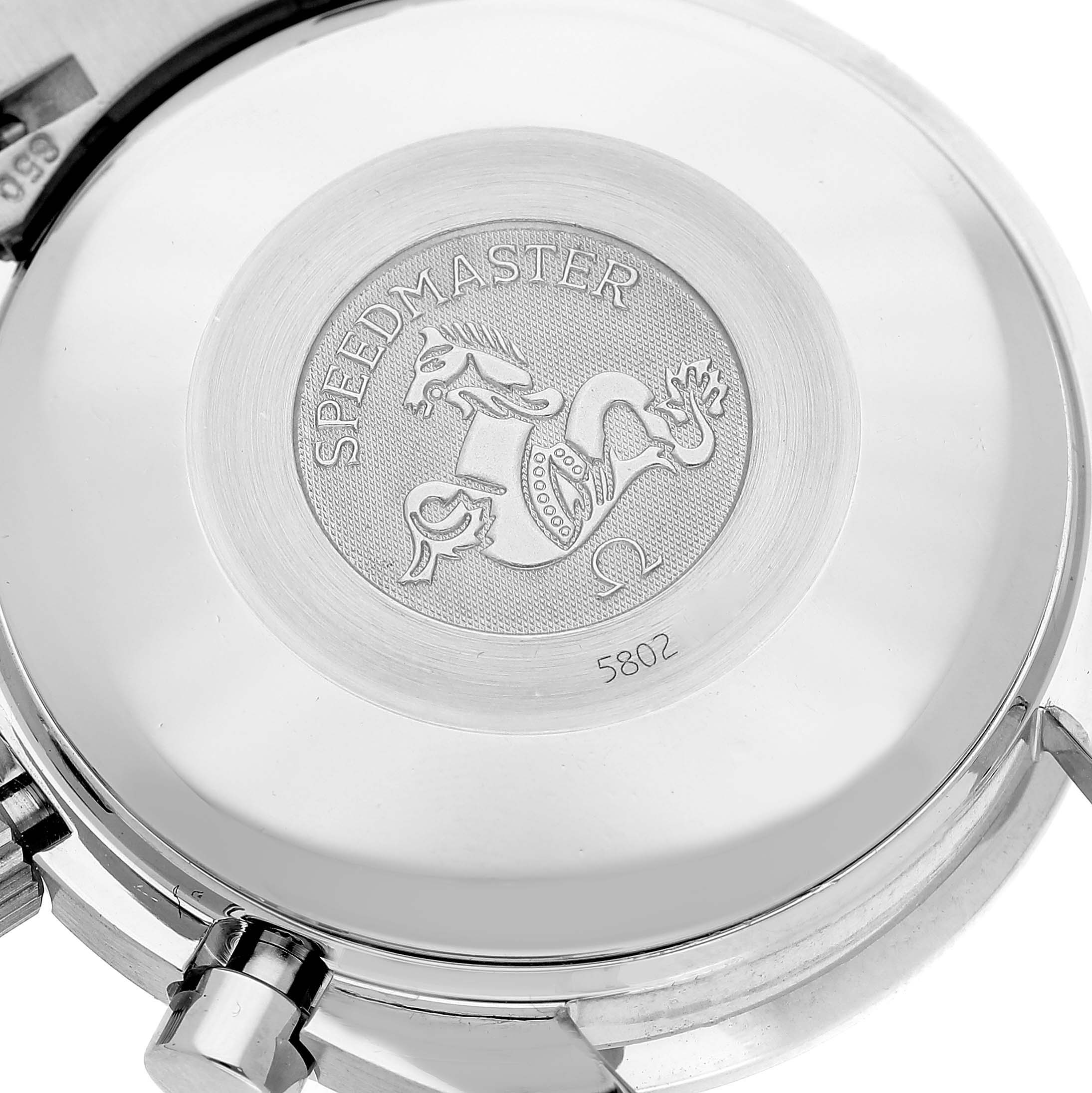 The image shows the case back of an Omega Speedmaster watch, displaying the engraved medallion.