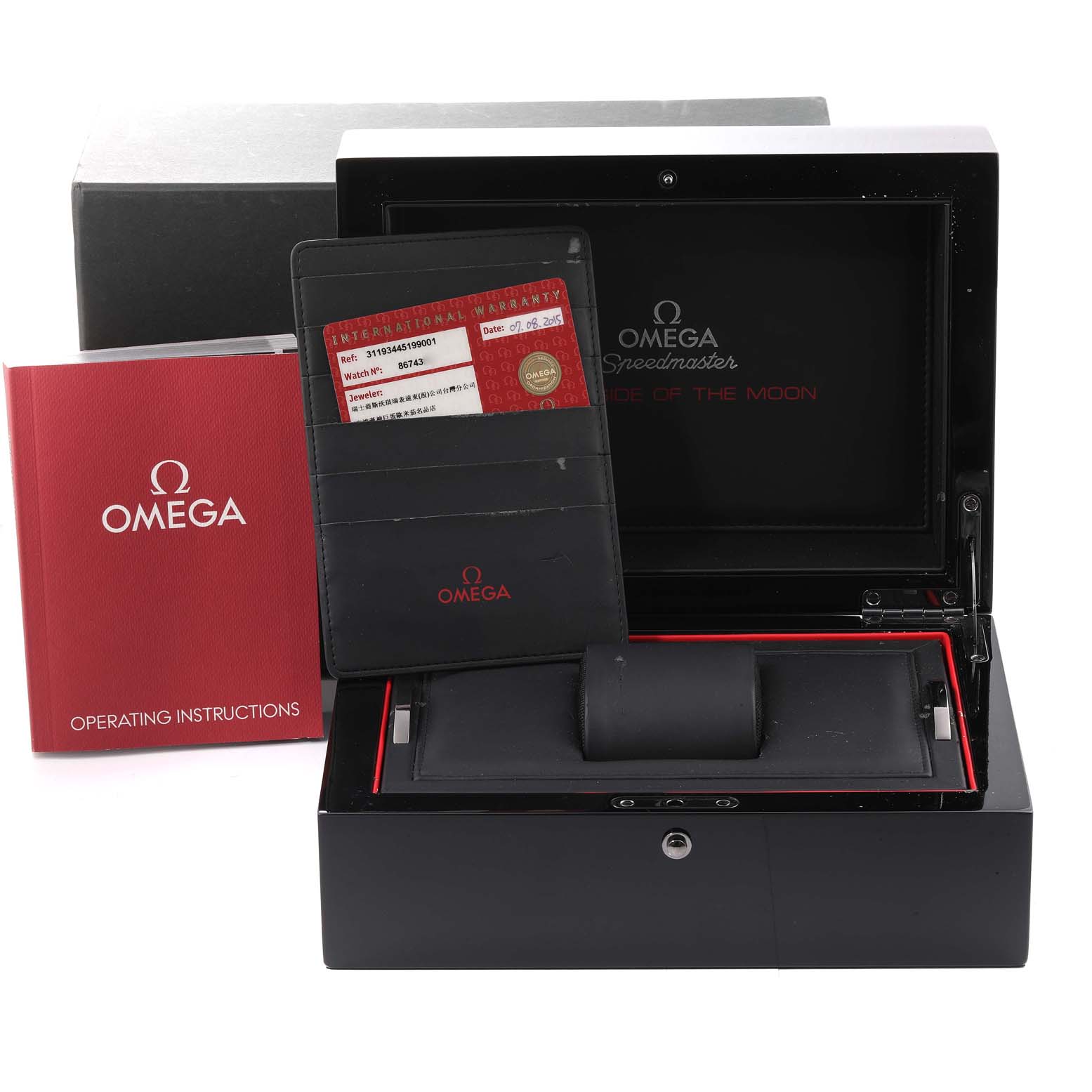 The image shows the open box of an Omega Speedmaster 311.93.44.51.99.001 Men's Ceramic Silver Dial 311.93.44.51.99.001 Men's Ceramic Silver Dial watch with the operating instructions and warranty card visible.