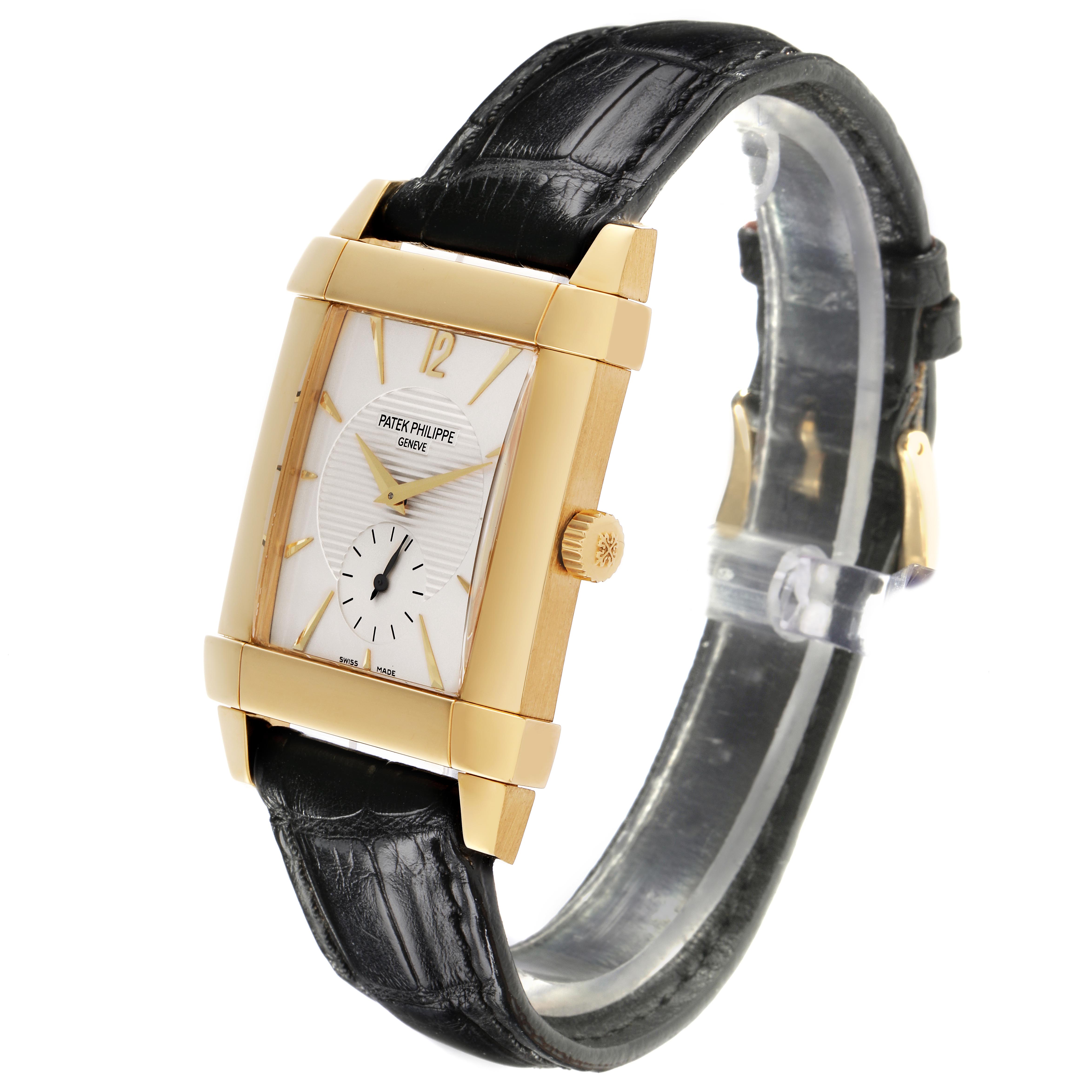 The Patek Philippe Gondolo 5111J-001 Men's Yellow Gold Silver Dial 5111J-001 Men's Yellow Gold Silver Dial watch is shown at a three-quarter angle, displaying its rectangular face, gold casing, and black strap.