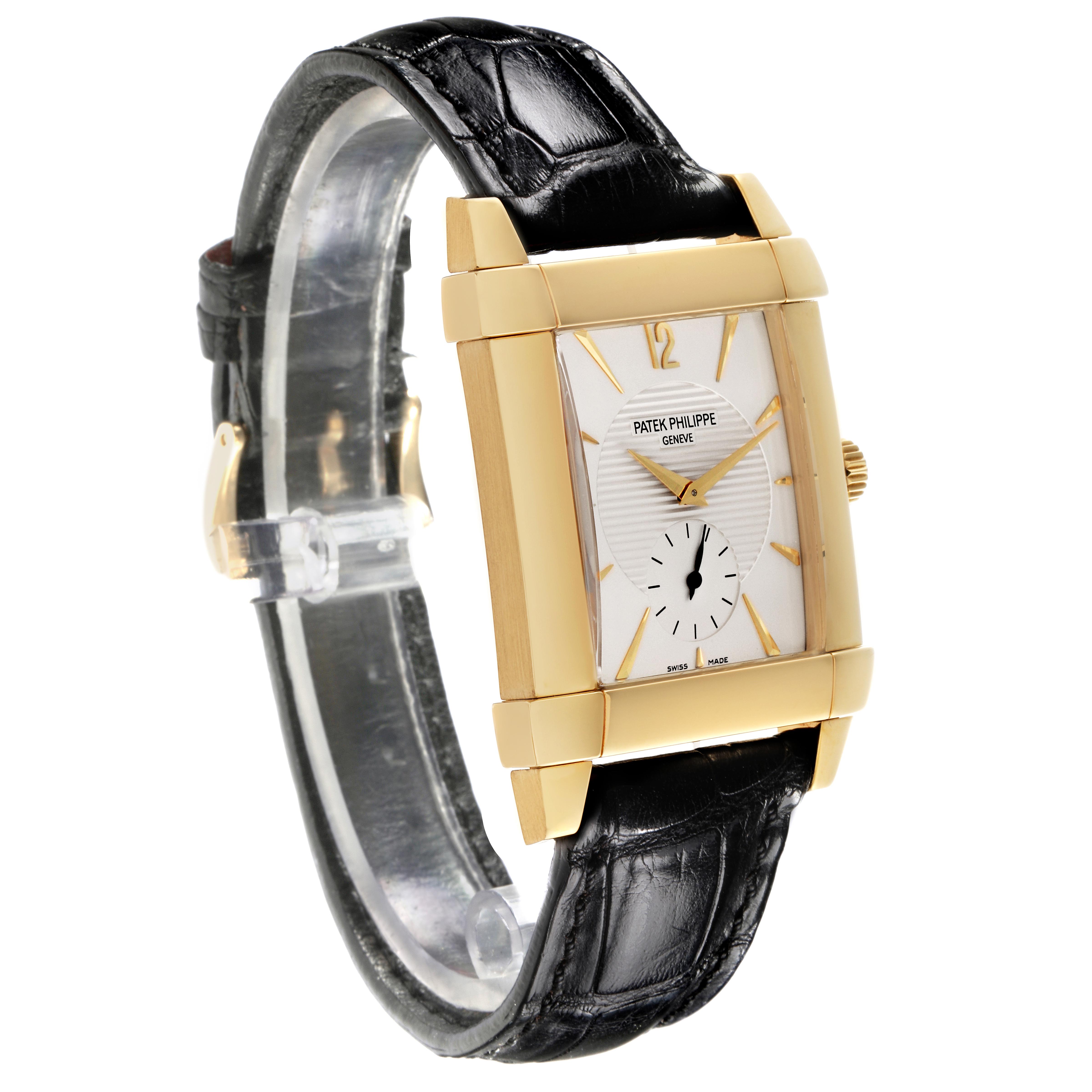 The image shows a Patek Philippe Gondolo 5111J-001 Men's Yellow Gold Silver Dial 5111J-001 Men's Yellow Gold Silver Dial watch at a slight angle, highlighting its rectangular face, gold casing, and black leather strap.