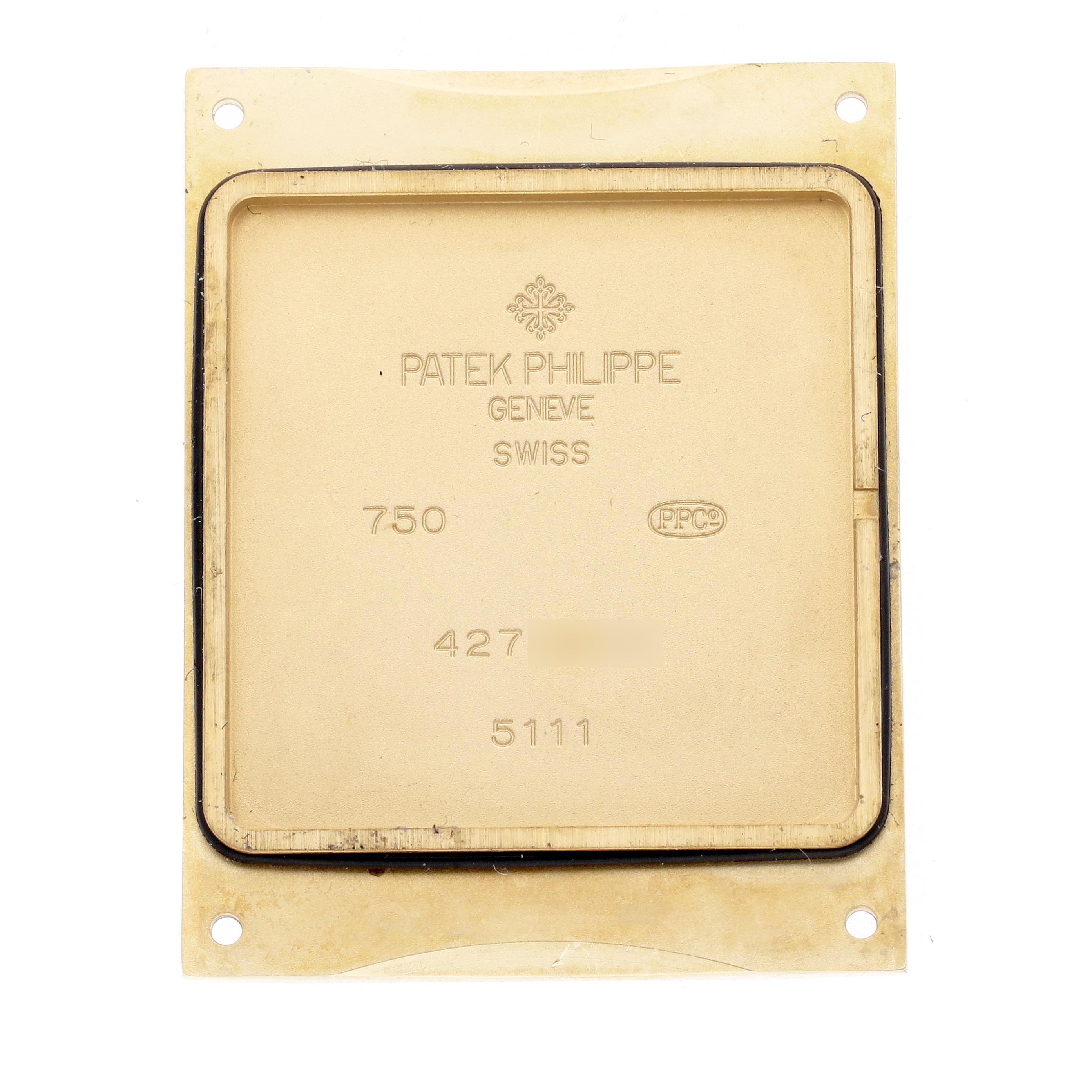 The image shows the back cover of a Patek Philippe Gondolo 5111J-001 Men's Yellow Gold Silver Dial 5111J-001 Men's Yellow Gold Silver Dial watch, displaying inscriptions and hallmark details.