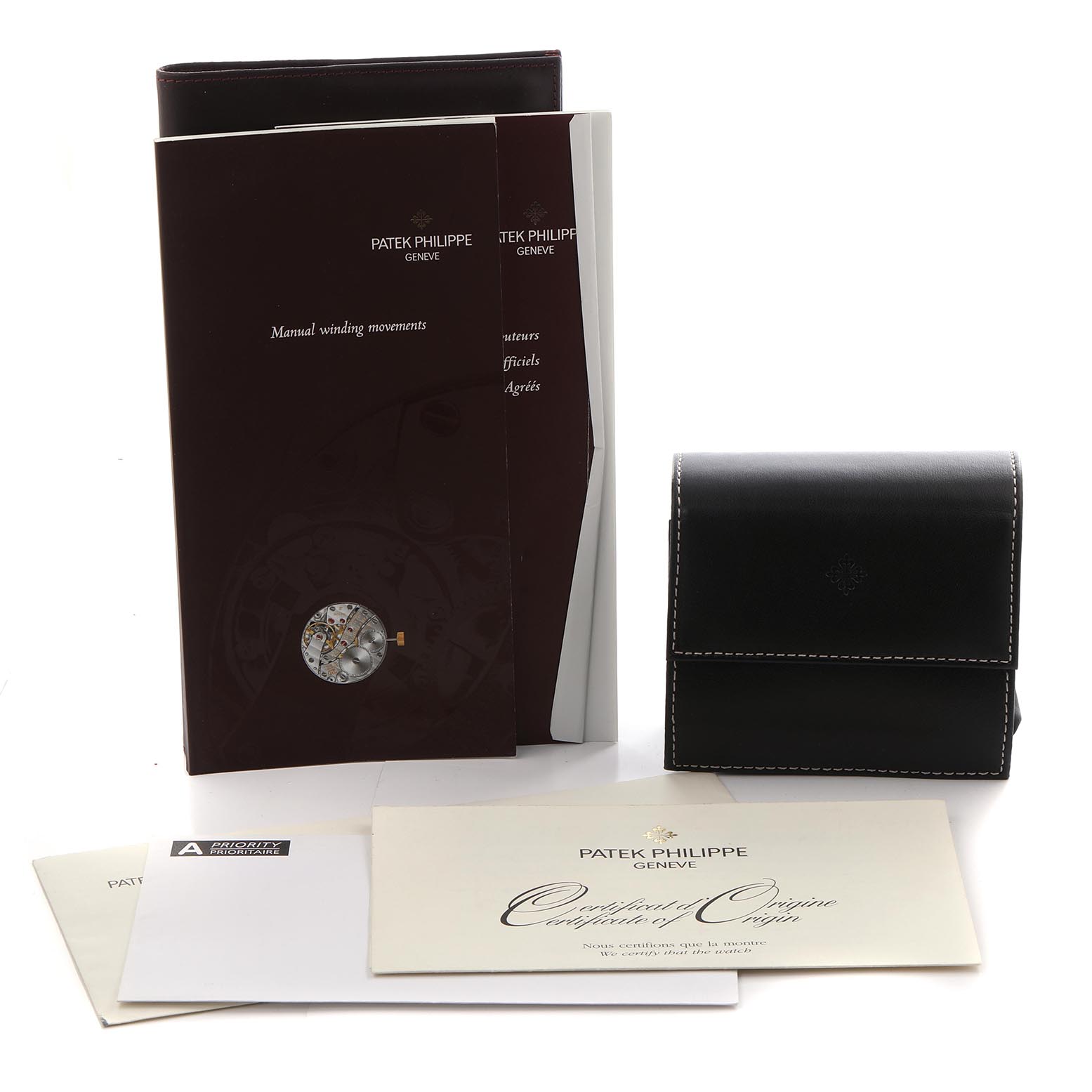 The image shows Patek Philippe Gondolo 5111J-001 Men's Yellow Gold Silver Dial 5111J-001 Men's Yellow Gold Silver Dial watch accessories including manuals, a case, and certificates from a front angle.