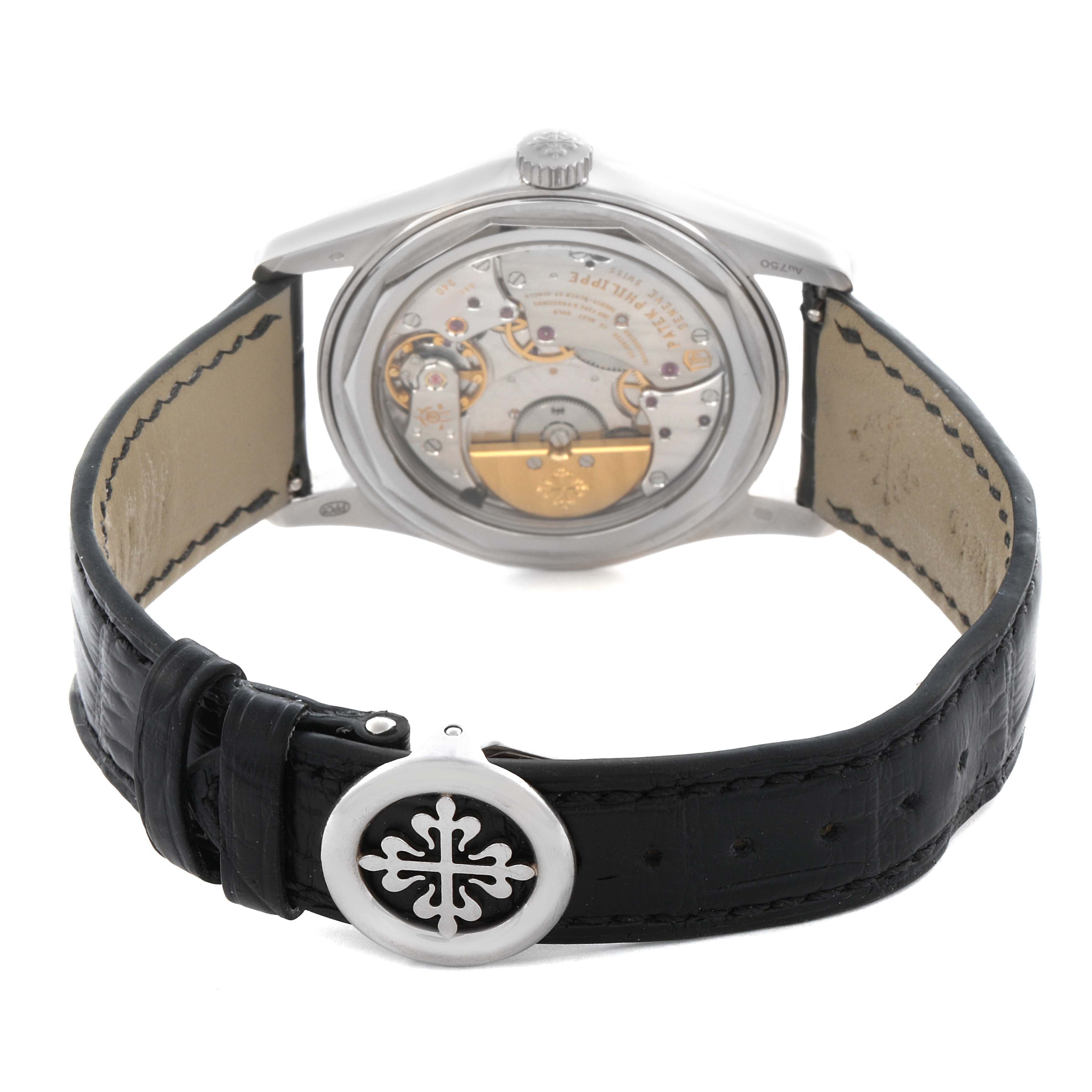 The Patek Philippe Calatrava 6000G-012 Men's White Gold Blue Dial 6000G-012 Men's White Gold Blue Dial watch is shown from the back, highlighting the movement and leather strap with a decorative buckle.