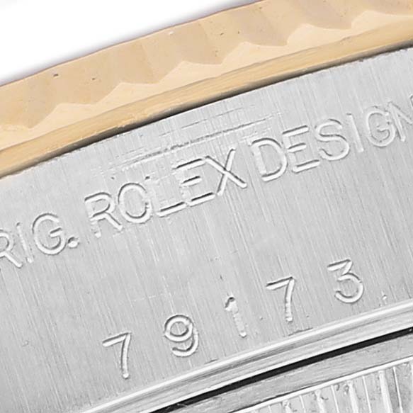 The image shows a close-up of the side of a Rolex Datejust 79173 Women's Stainless Steel Black Dial, highlighting engraved text and part of the bezel.