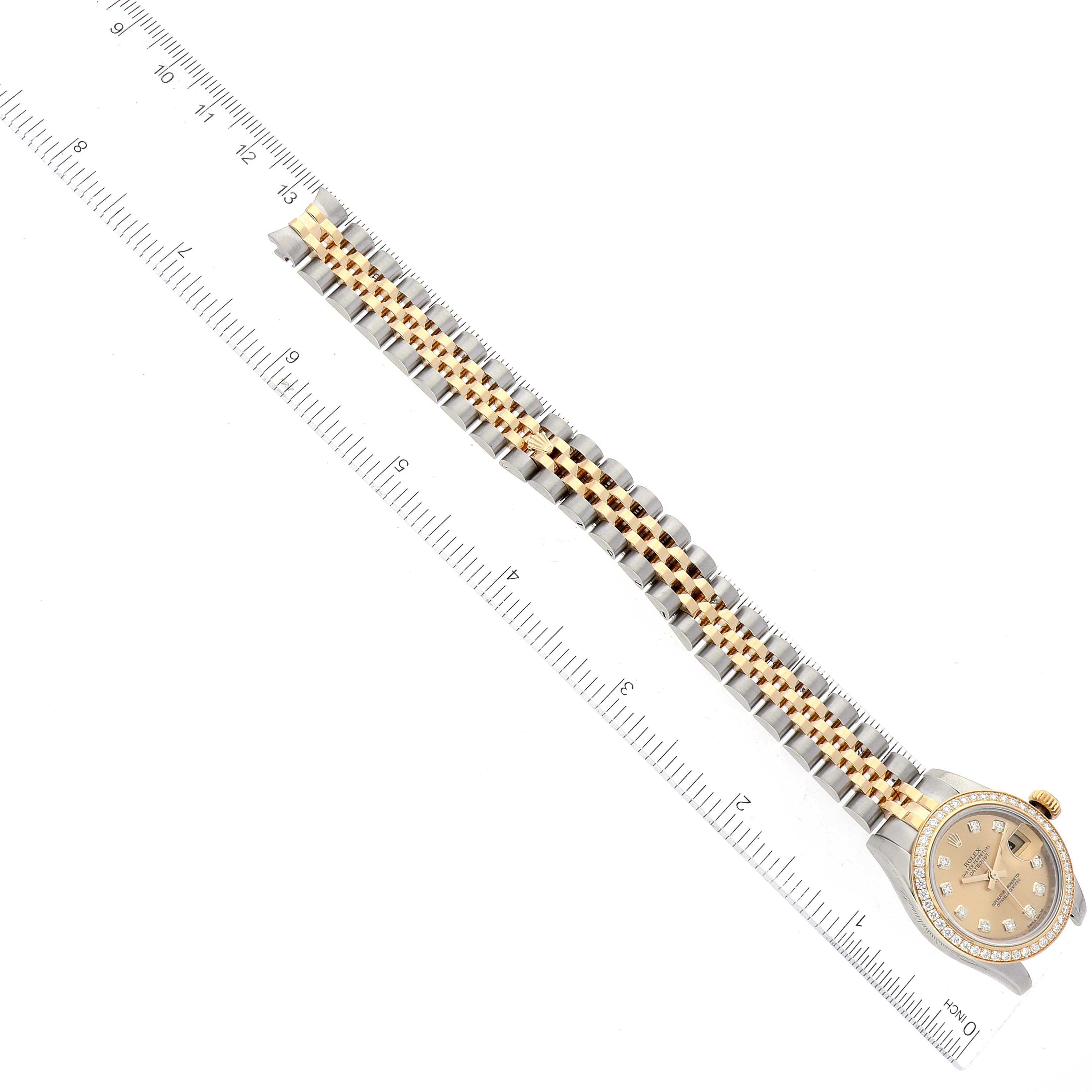 Aerial view of a Rolex Datejust 179383 Women's Steel and Gold (two tone) Champagne Dial 179383 Women's Steel and Gold (two tone) Champagne Dial watch, showcasing the full band and face, alongside a ruler for scale.