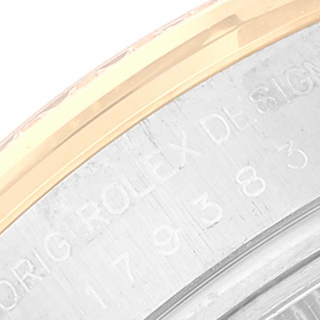 This image shows a close-up of the side of a Rolex Datejust 179383 Women's Steel and Gold (two tone) Silver Dial 179383 Women's Steel and Gold (two tone) Silver Dial watch case, focusing on the engraved serial number and part of the bezel.