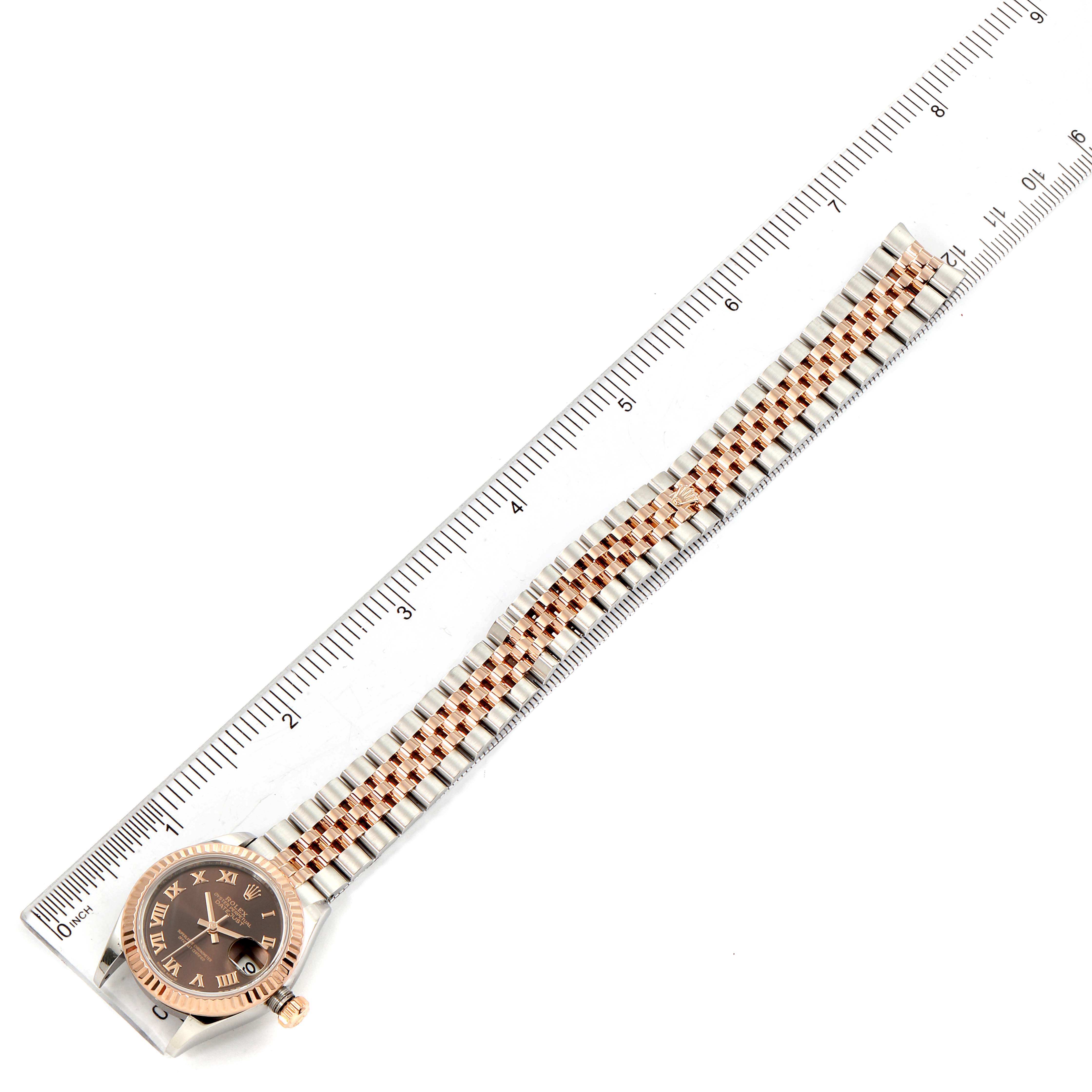 The image shows a Rolex Datejust 279171 Women's Steel and Gold (two tone) Brown Dial 279171 Women's Steel and Gold (two tone) Brown Dial watch placed next to a ruler, displaying the entire watch including the face and band.