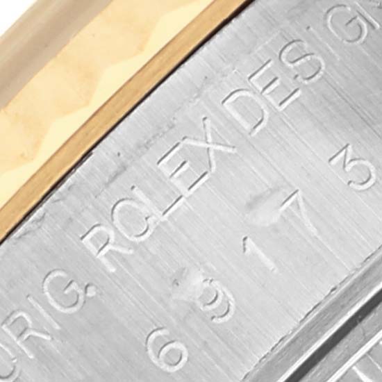 The image shows the side of a Rolex Datejust 69173 Women's Steel and Gold (two tone) White Dial 69173 Women's Steel and Gold (two tone) White Dial watch, focusing on the engraved inner bezel and part of the fluted bezel.