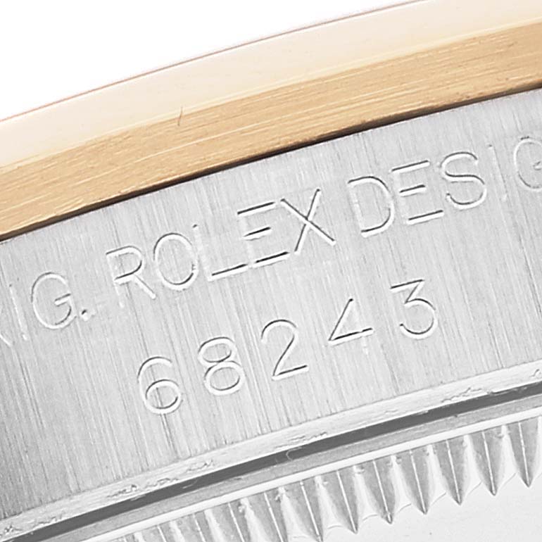 The image shows a close-up of the case and bezel edge of a mid-size Rolex watch, with its model number 68243 engraved.