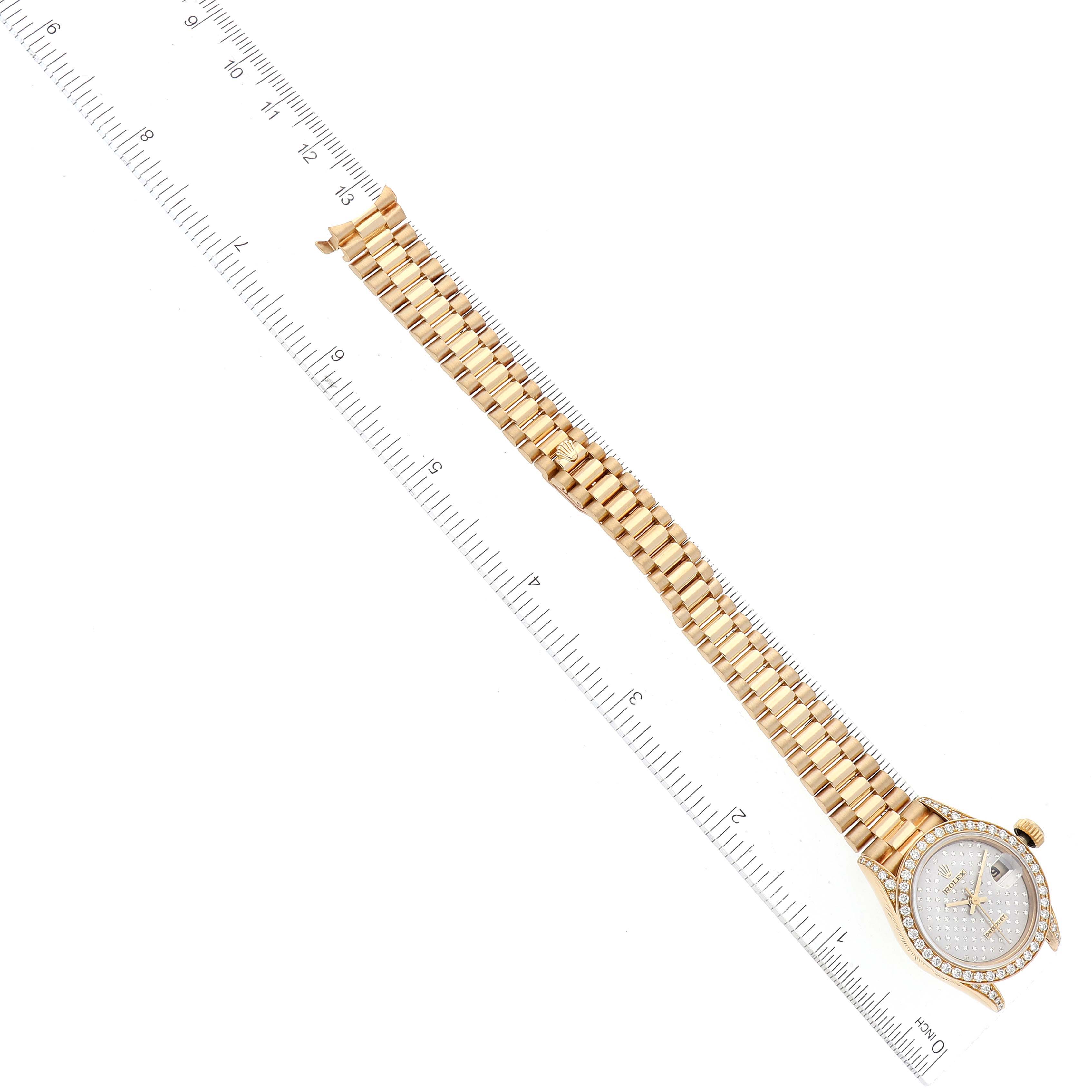 This image shows the front view of a Rolex President 69158 Women's Yellow Gold Silver Dial 69158 Women's Yellow Gold Silver Dial model with its full bracelet and a ruler for scale.