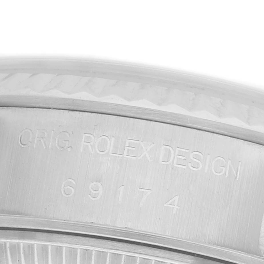 The image shows a close-up of the side of a Rolex Datejust 69174 Women's Stainless Steel Blue Dial 69174 Women's Stainless Steel Blue Dial watch case with engravings of the model number.