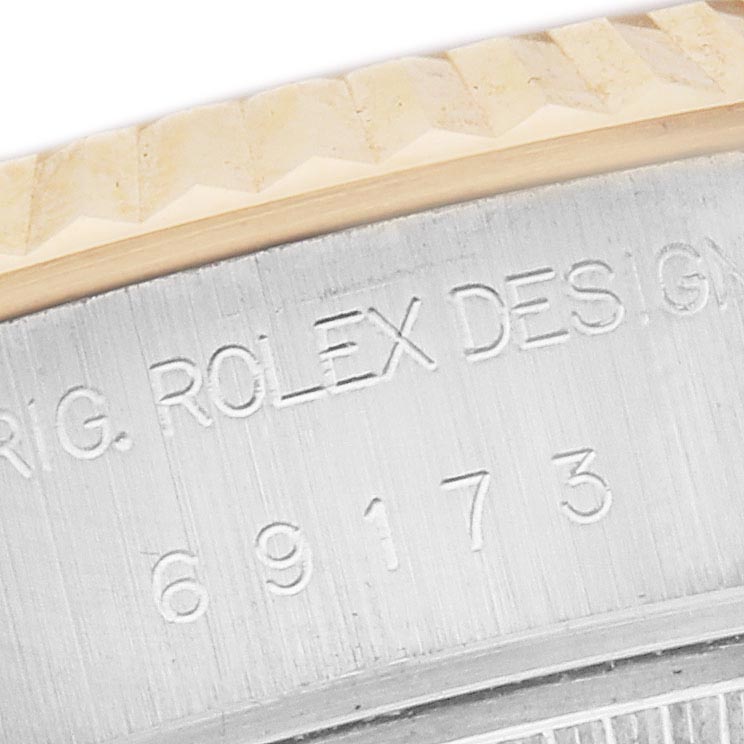 The image shows a close-up of the Rolex Datejust 69173 Women's Steel and Gold (two tone) Champagne Dial 69173 Women's Steel and Gold (two tone) Champagne Dial model, highlighting the engraved side with the model number and fluted bezel.