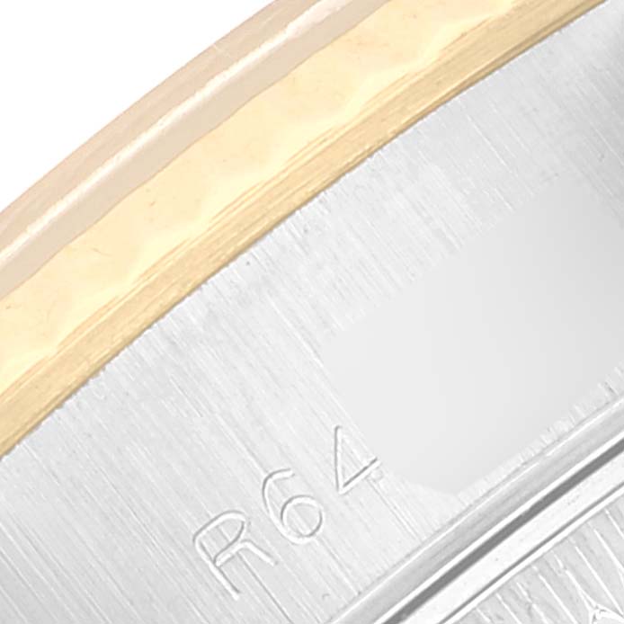 This image shows a close-up of the edge and part of the bezel of a Rolex Datejust 69173 Women's Steel and Gold (two tone) Champagne Dial 69173 Women's Steel and Gold (two tone) Champagne Dial watch with engraved markings.