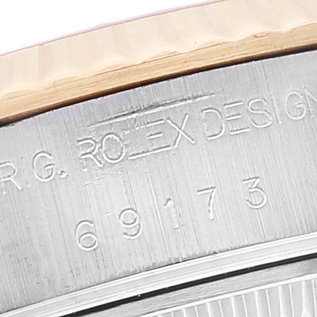 The image shows the side engraving and serial number of the Rolex Datejust 69173 Women's Steel and Gold (two tone) Champagne Dial 69173 Women's Steel and Gold (two tone) Champagne Dial model, focusing on the metal edge near the bezel.