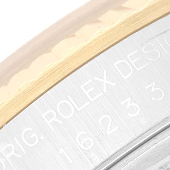 The image shows a close-up view of the bezel and engraving on the side of a Rolex Datejust 16233 Men's Steel and Gold (two tone) Silver Dial 16233 Men's Steel and Gold (two tone) Silver Dial watch.