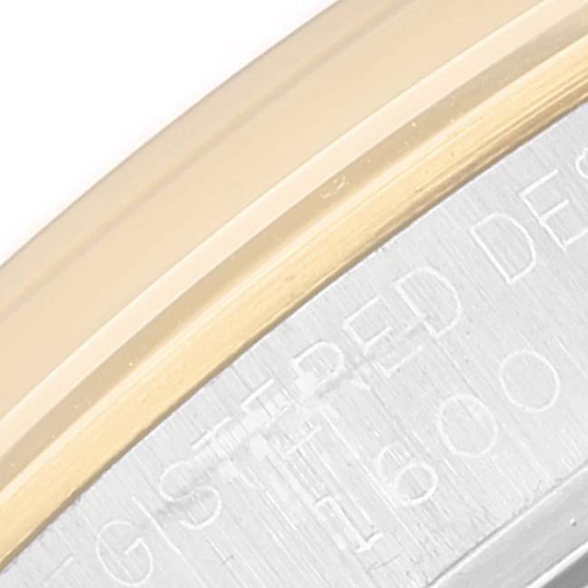 The image shows a close-up of the side edge and part of the engraved back of a Vintage Collection model by Rolex.