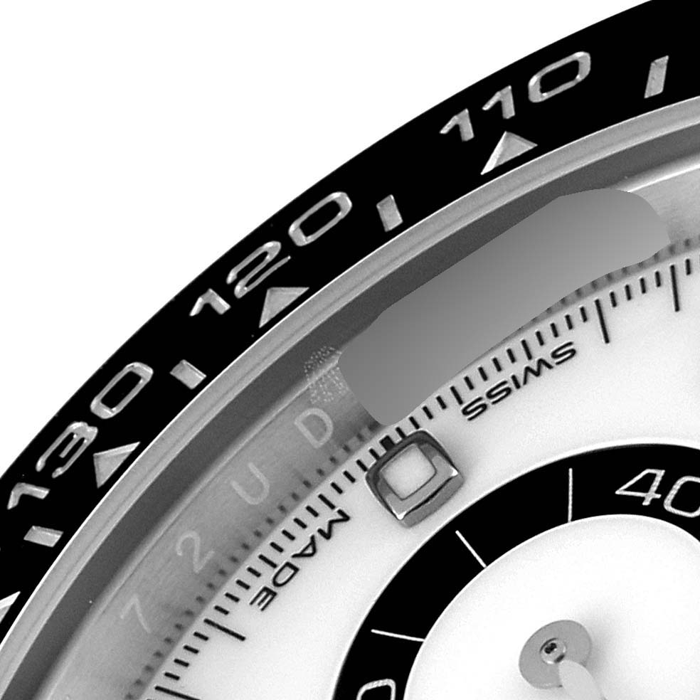 The image shows a close-up of the bezel and part of the dial of a Rolex Daytona 116500 Men's Stainless Steel White Dial 116500 Men's Stainless Steel White Dial watch.