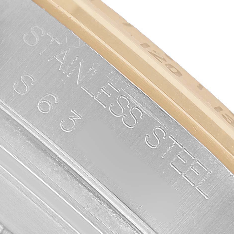 The image shows a close-up of the bezel and engraved side of a Rolex Daytona 16523 Men's Steel and Gold (two tone) White Dial watch, highlighting "Stainless Steel" text.
