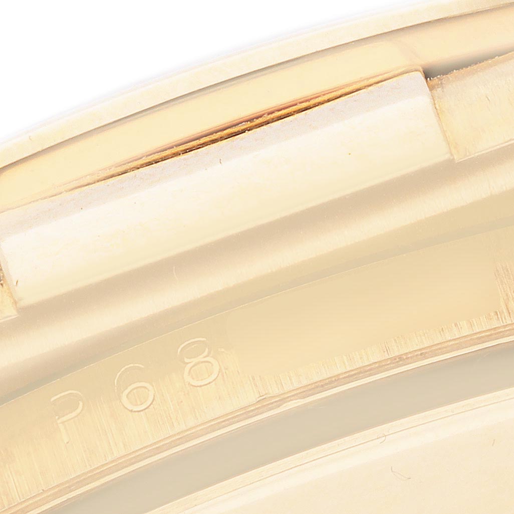 The image shows a close-up of the Rolex Daytona 116518 Men's Yellow Gold Black Dial 116518 Men's Yellow Gold Black Dial model's case side, focusing on engraved serial numbers.