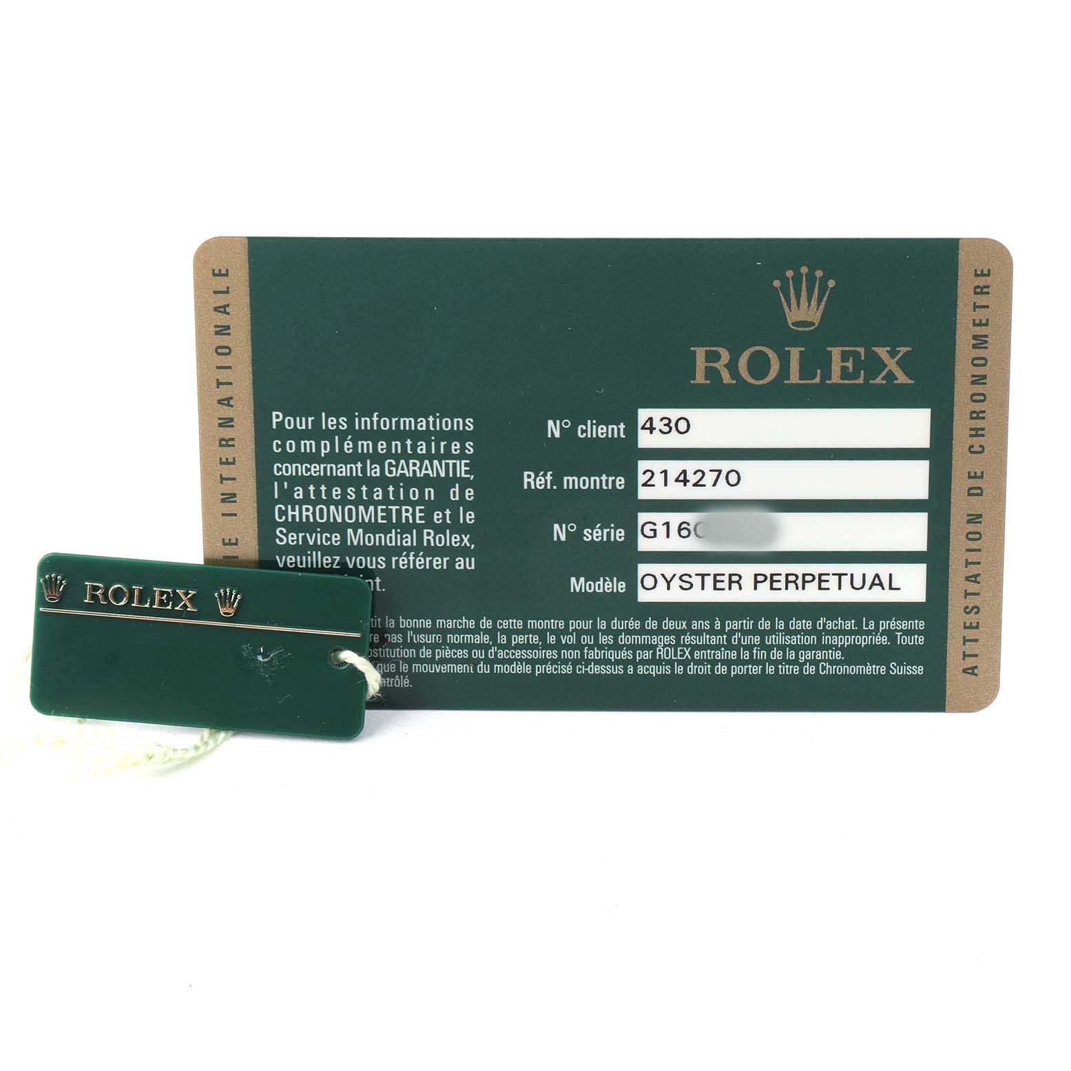 The image shows a guarantee card and a tag for the Rolex Explorer 214270 Men's Stainless Steel Black Dial model, reference 214270, laid flat.