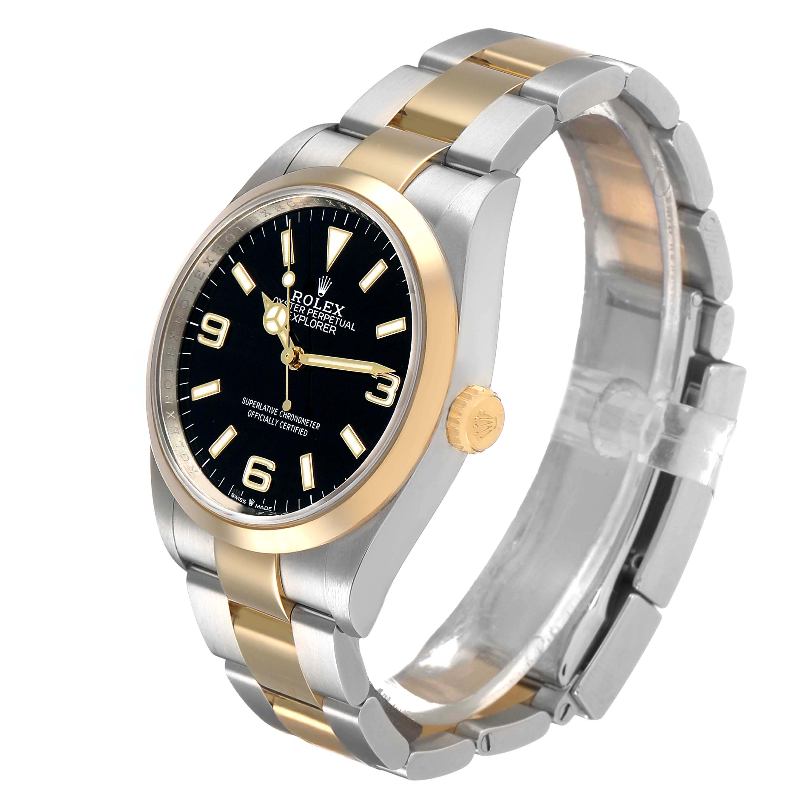 The Rolex Explorer 124273 Men's Steel and Gold (two tone) Black Dial watch is shown from a side angle, displaying the face, bezel, crown, and bracelet.