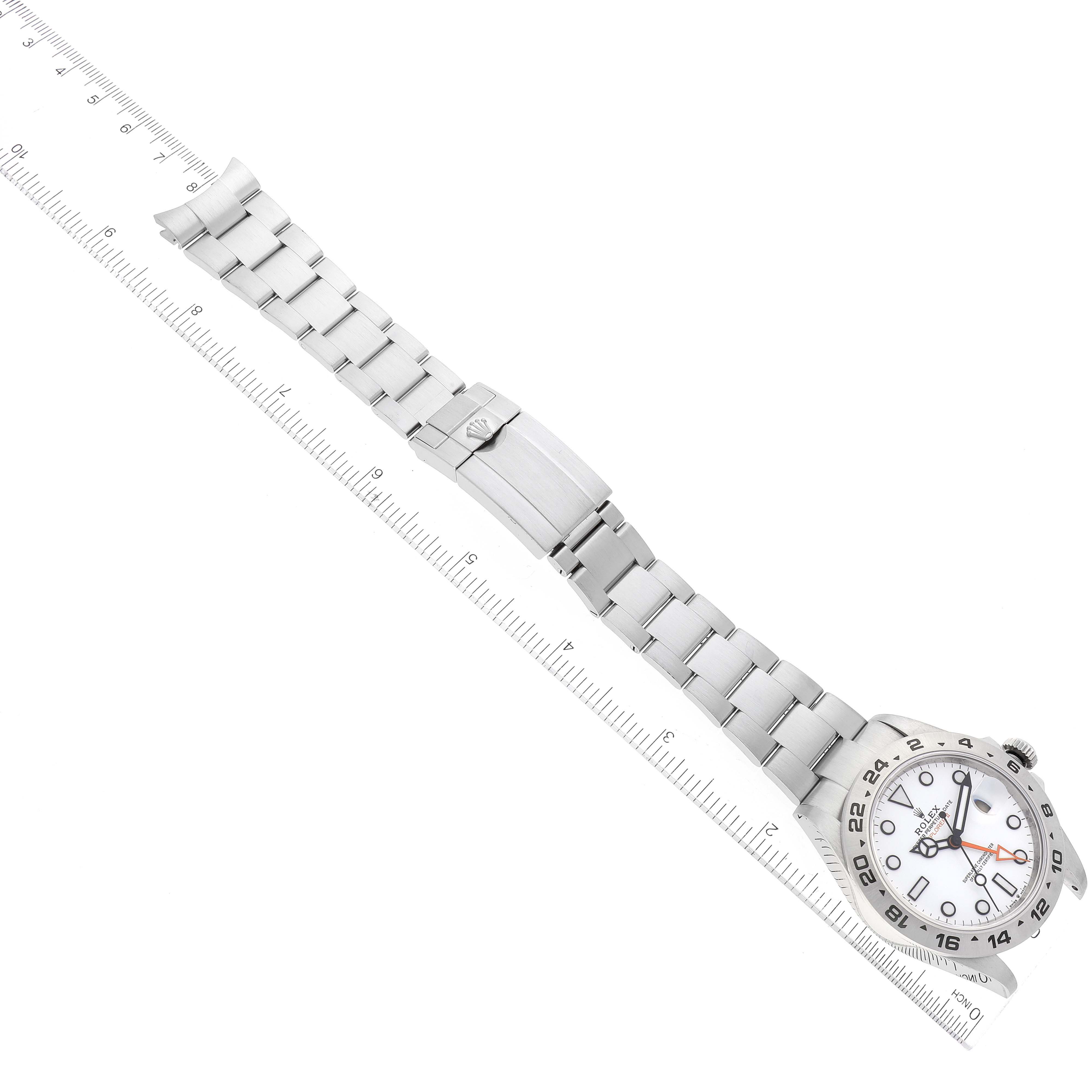 The Rolex Explorer 226570 Men
s Stainless Steel White Dial 226570 Men
s Stainless Steel White Dial watch is shown from a top-down angle, showcasing its face and metal bracelet with a ruler for scale.