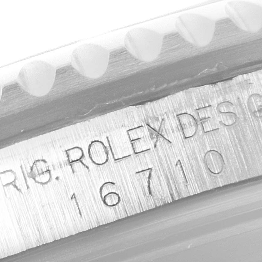 The image shows a close-up of the side of the bezel and engraved serial number of a Rolex GMT-Master 16710 Men
s Stainless Steel Black Dial 16710 Men
s Stainless Steel Black Dial model.
