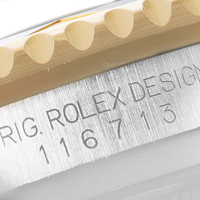 This close-up image of a Rolex GMT-Master 116713 Men's Steel and Gold (two tone) Black Dial 116713 Men's Steel and Gold (two tone) Black Dial watch shows the side profile, focusing on the model number and engravings.