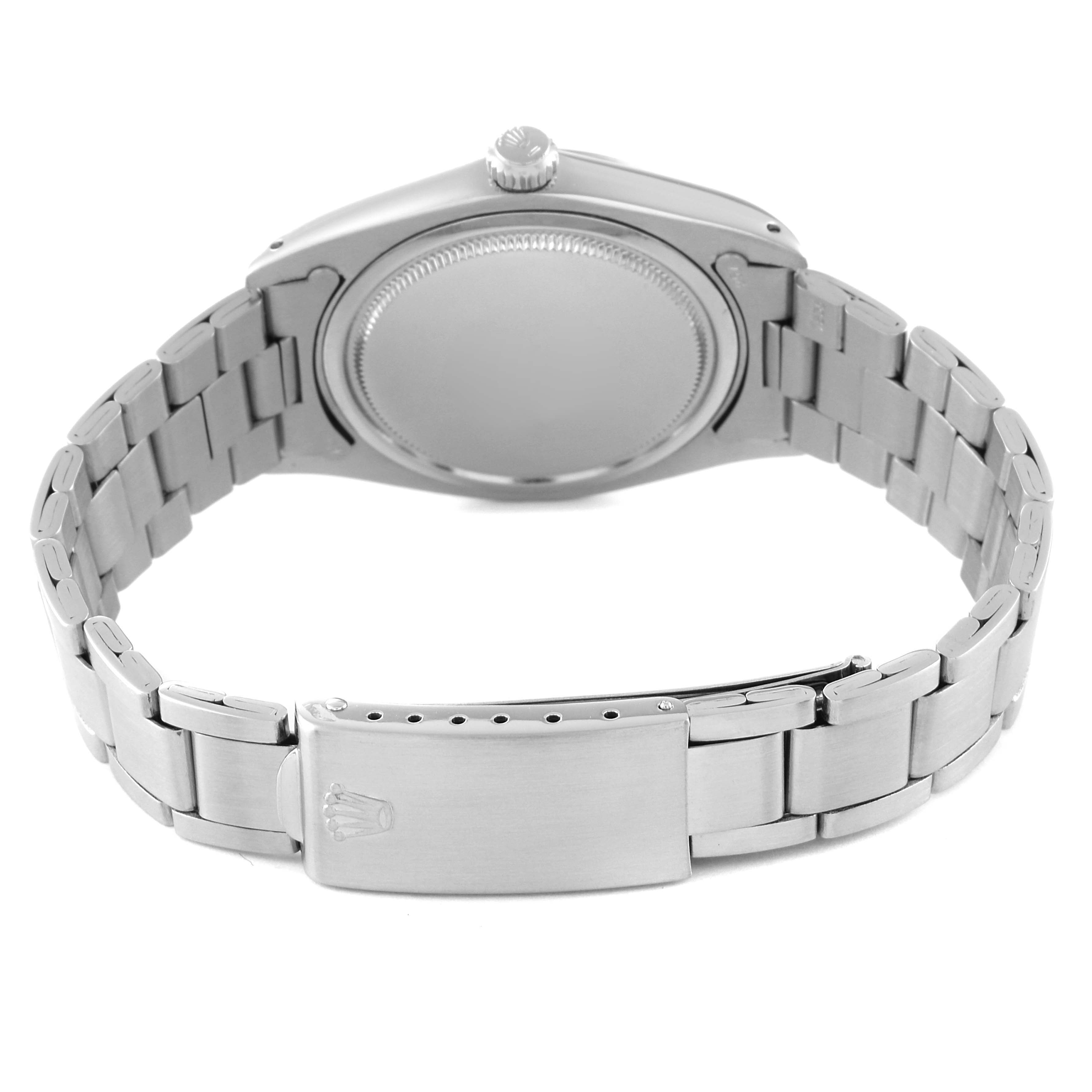 The image shows the back side of a Rolex Vintage Collection 6694 Men
s Stainless Steel Silver Dial 6694 Men
s Stainless Steel Silver Dial watch, highlighting its stainless steel case and bracelet with the clasp.