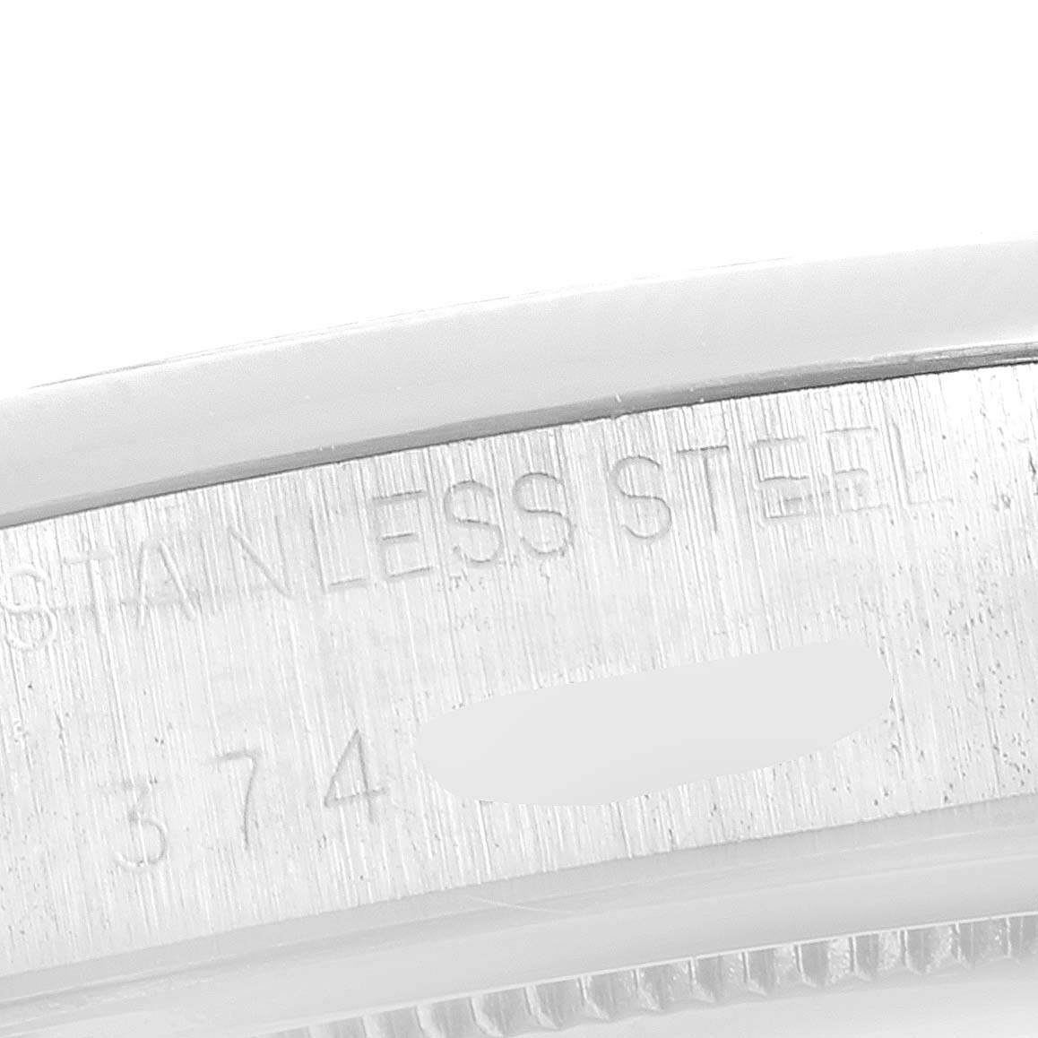 This close-up image shows the side engraving of the bezel on a Rolex Vintage Collection 6694 Men's Stainless Steel Champagne Dial 6694 Men's Stainless Steel Champagne Dial watch, highlighting "Stainless Steel."