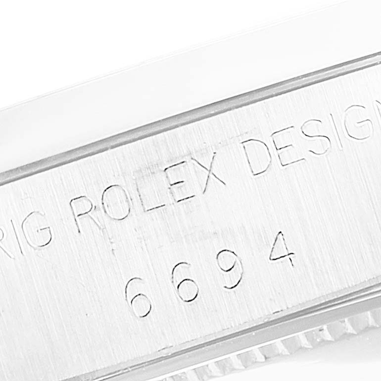 The image shows an angled view of the casing with "Rolex Design 6694" engraving on the Vintage Collection model by Rolex.