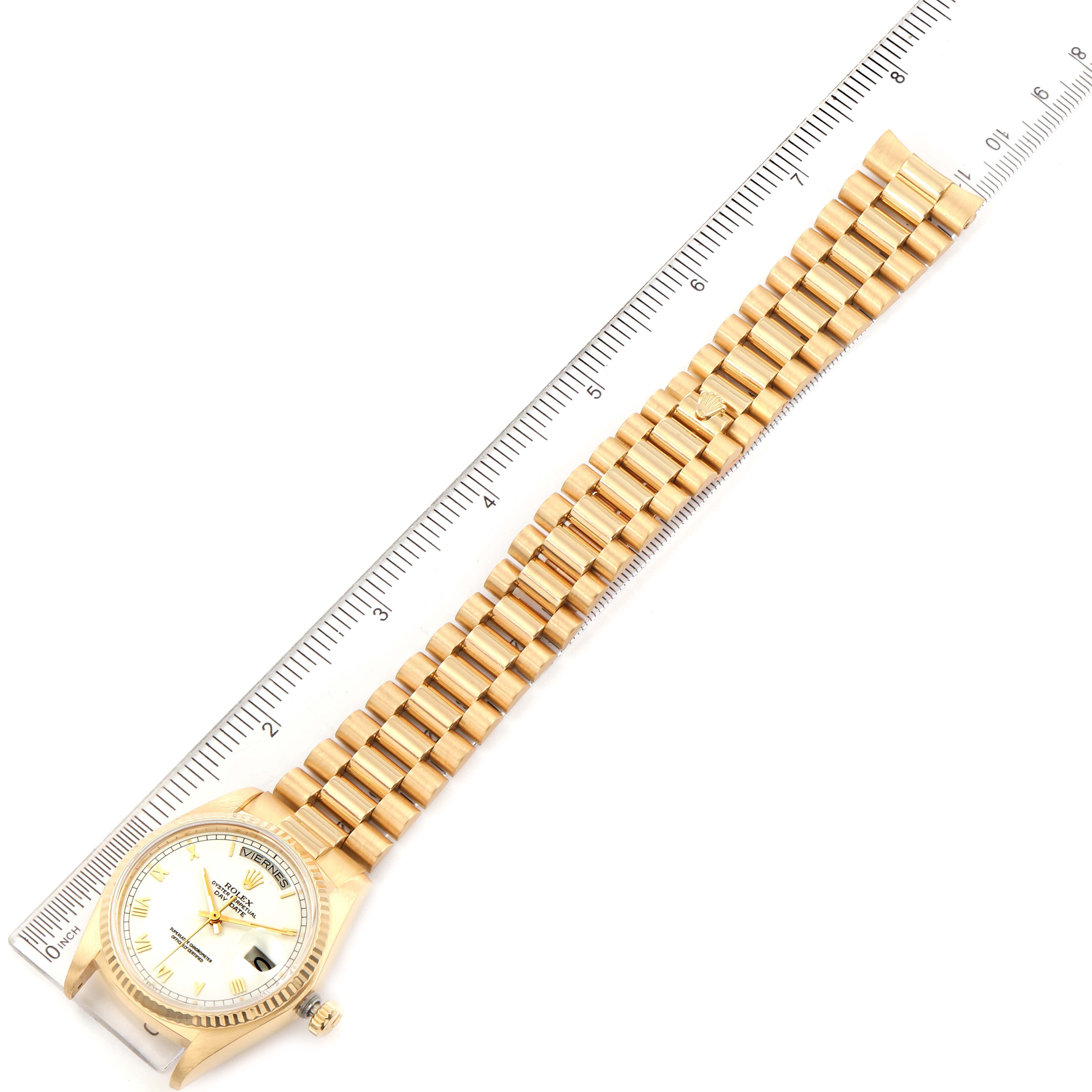 The image shows a top-down view of a Rolex President 18038 Men's Yellow Gold White Dial 18038 Men's Yellow Gold White Dial model watch, highlighting the dial, bezel, and bracelet alongside a ruler.