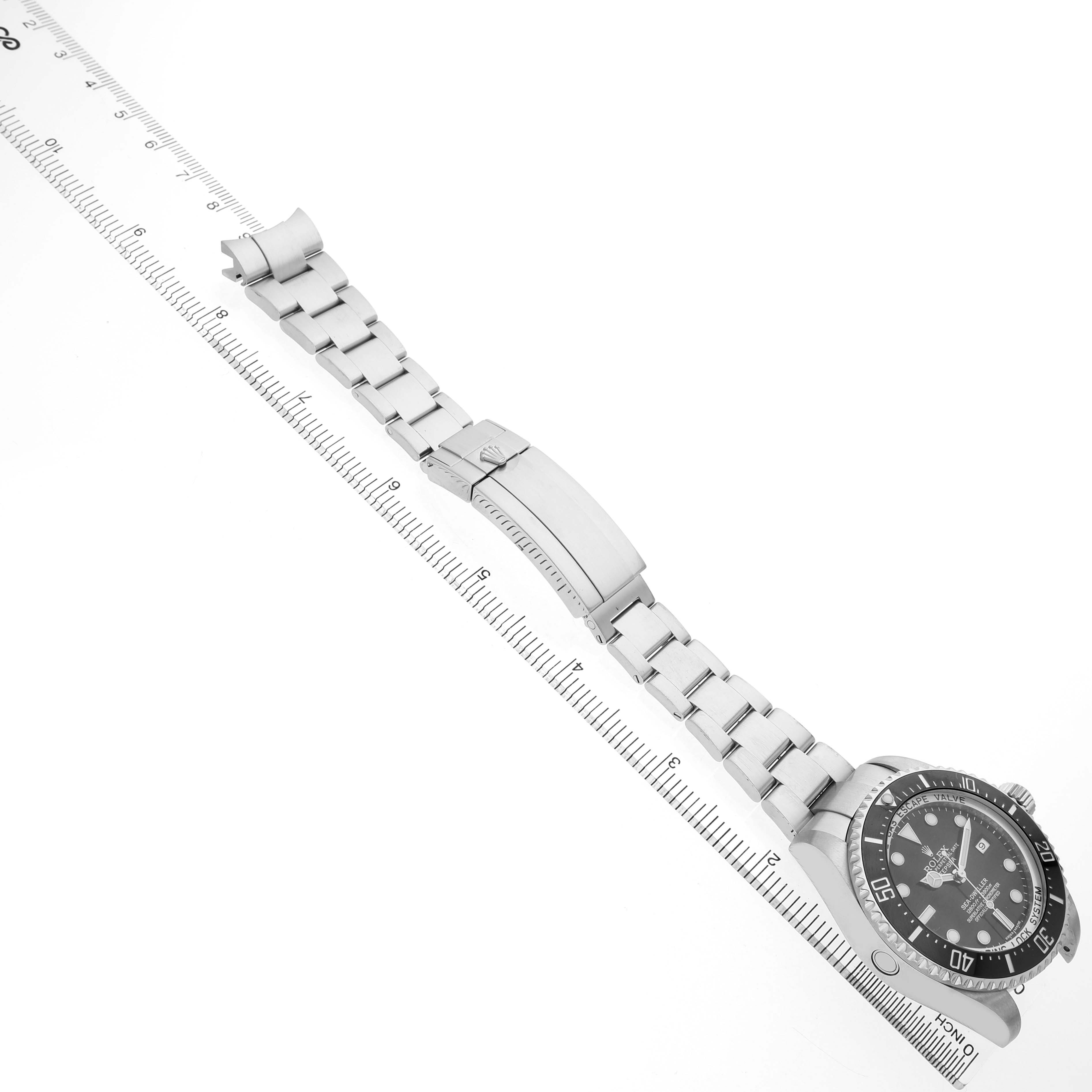 The image shows a Rolex Sea-Dweller 116660 Men's Stainless Steel Black Dial watch lying flat with its bracelet stretched, alongside a ruler for scale.