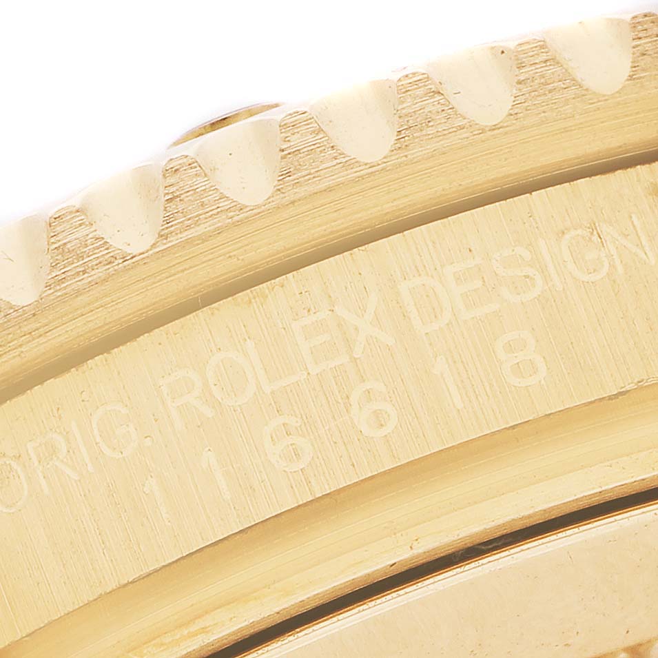 The image captures the engraved side of the Rolex Submariner 116618 Men's Yellow Gold Black Dial's gold bezel, showing part of the model and design numbers.
