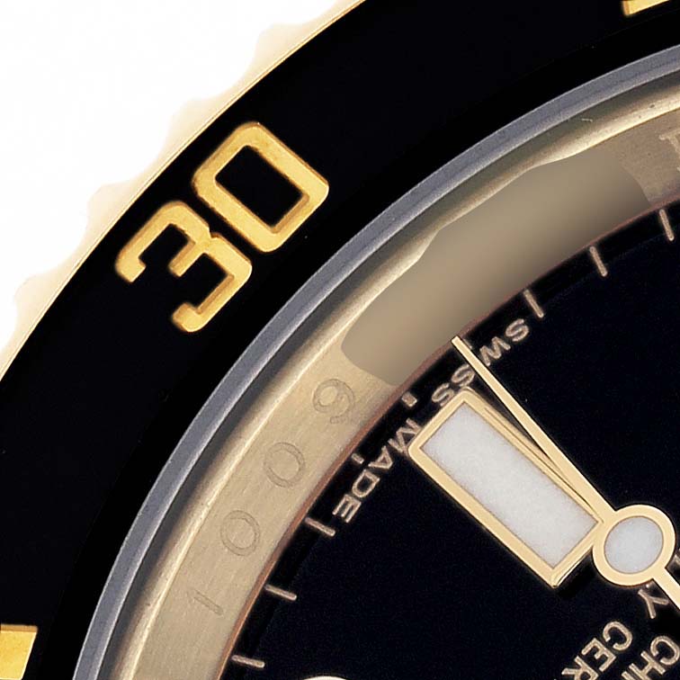 The image shows a close-up of the Rolex Submariner 116618 Men's Yellow Gold Black Dial's bezel, dial, and hand, focusing on the 30-minute mark.