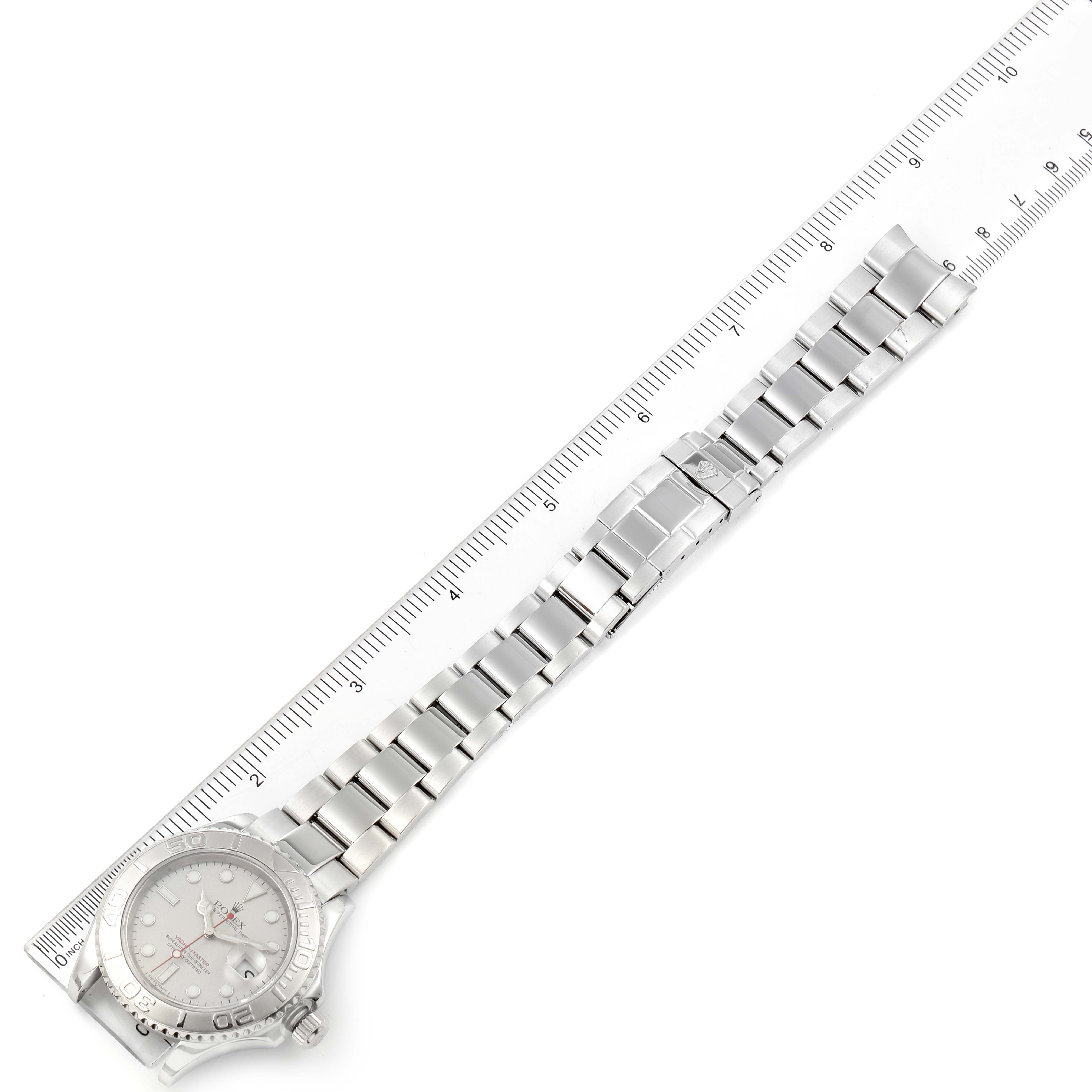 The Rolex Yacht-Master 16622 Men
s Stainless Steel Silver Dial 16622 Men
s Stainless Steel Silver Dial watch is shown in full length from a top angle, including the bezel, dial, and bracelet, next to a ruler for scale.