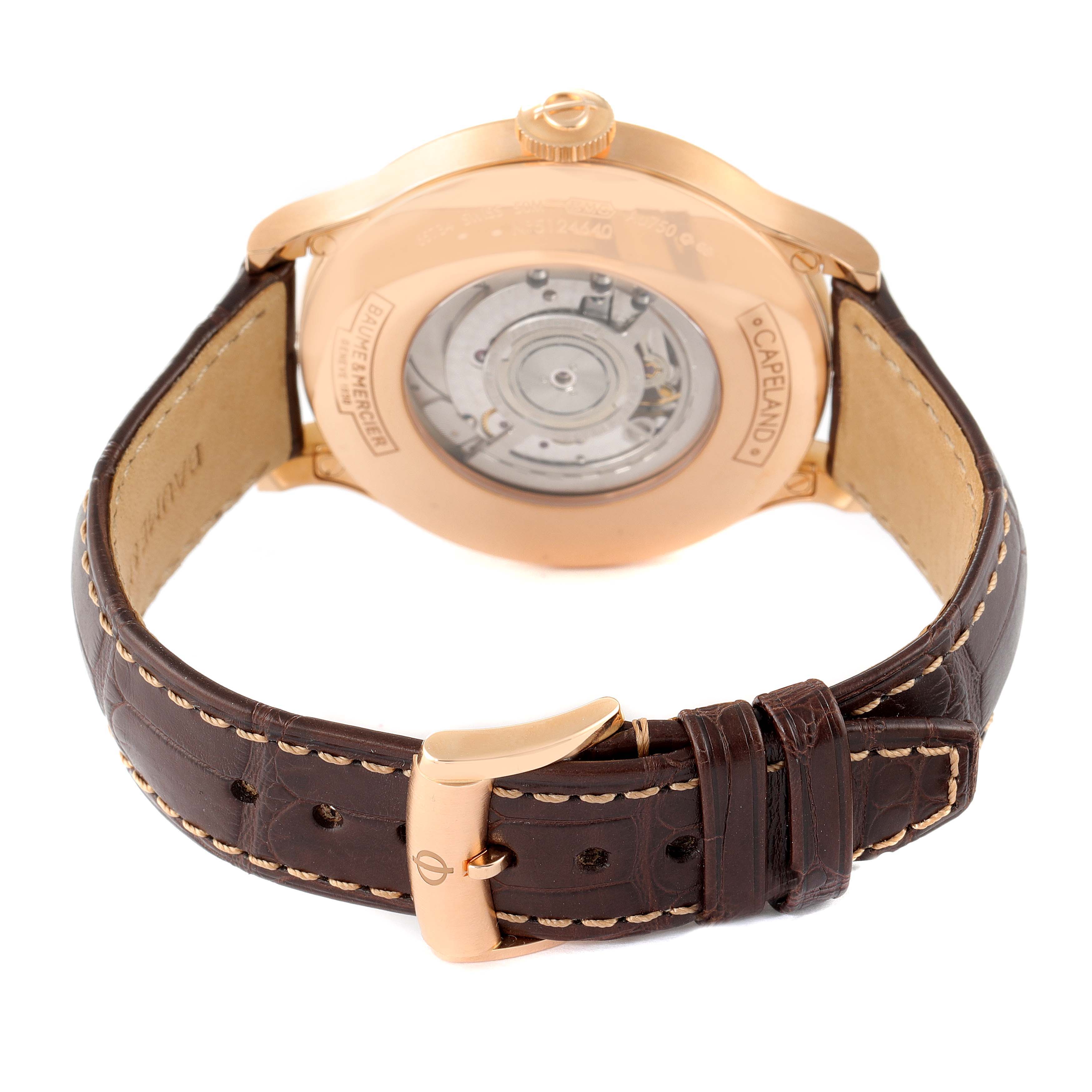 The image shows the back view of the Baume & Mercier Capeland M0A10107 Men's Rose Gold Silver Dial M0A10107 Men's Rose Gold Silver Dial watch, focusing on its case back and leather strap with the buckle.