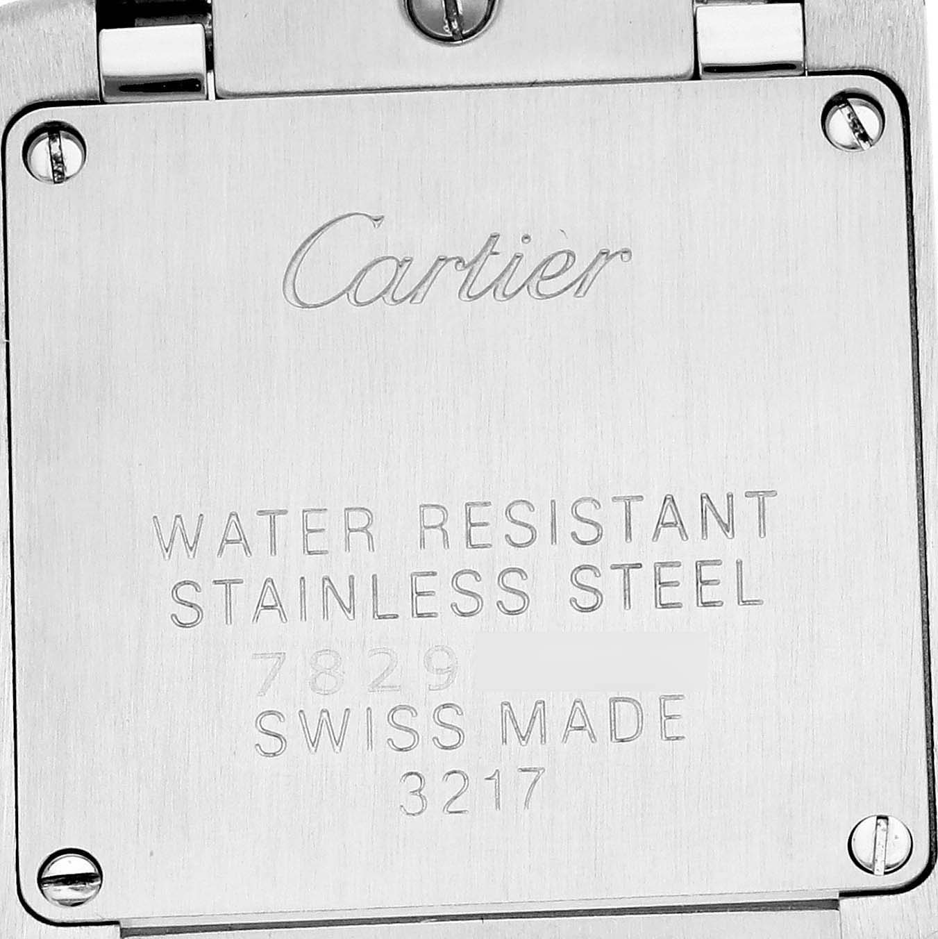 The image shows the back case of a Cartier Tank Française watch, featuring engraving details and screws.