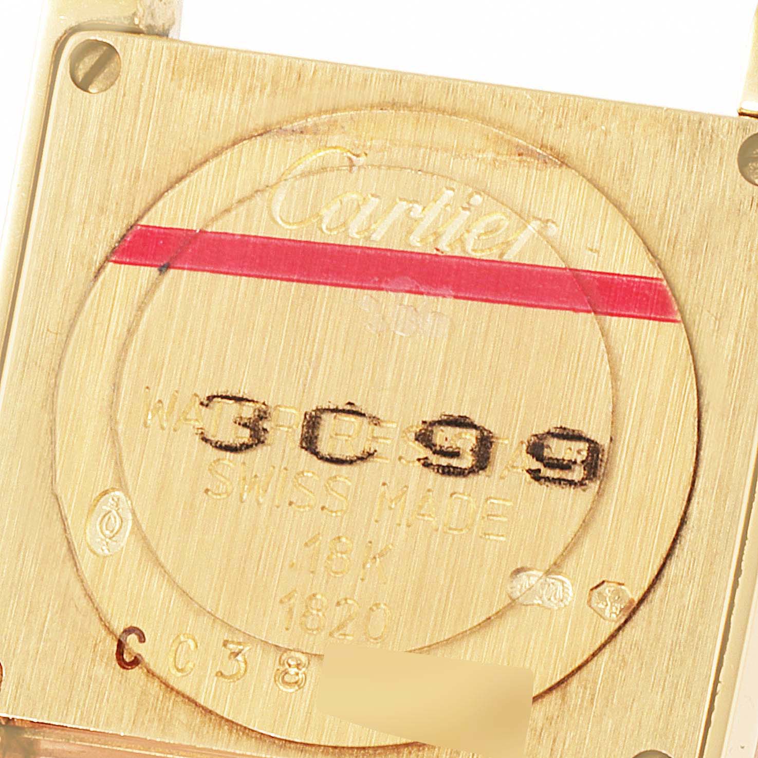 This is a close-up image of the back case of a Cartier Tank Francaise W5000256 Women's Yellow Gold Silver Dial W5000256 Women's Yellow Gold Silver Dial watch, displaying the engravings and serial number.