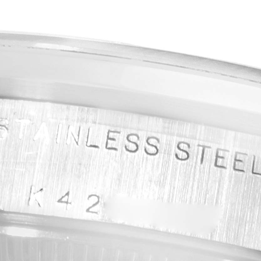 The image shows a close-up of the case side of a Rolex Mid-Size 78240 Women
s Stainless Steel White Dial 78240 Women
s Stainless Steel White Dial model, showcasing "STAINLESS STEEL" engraving.