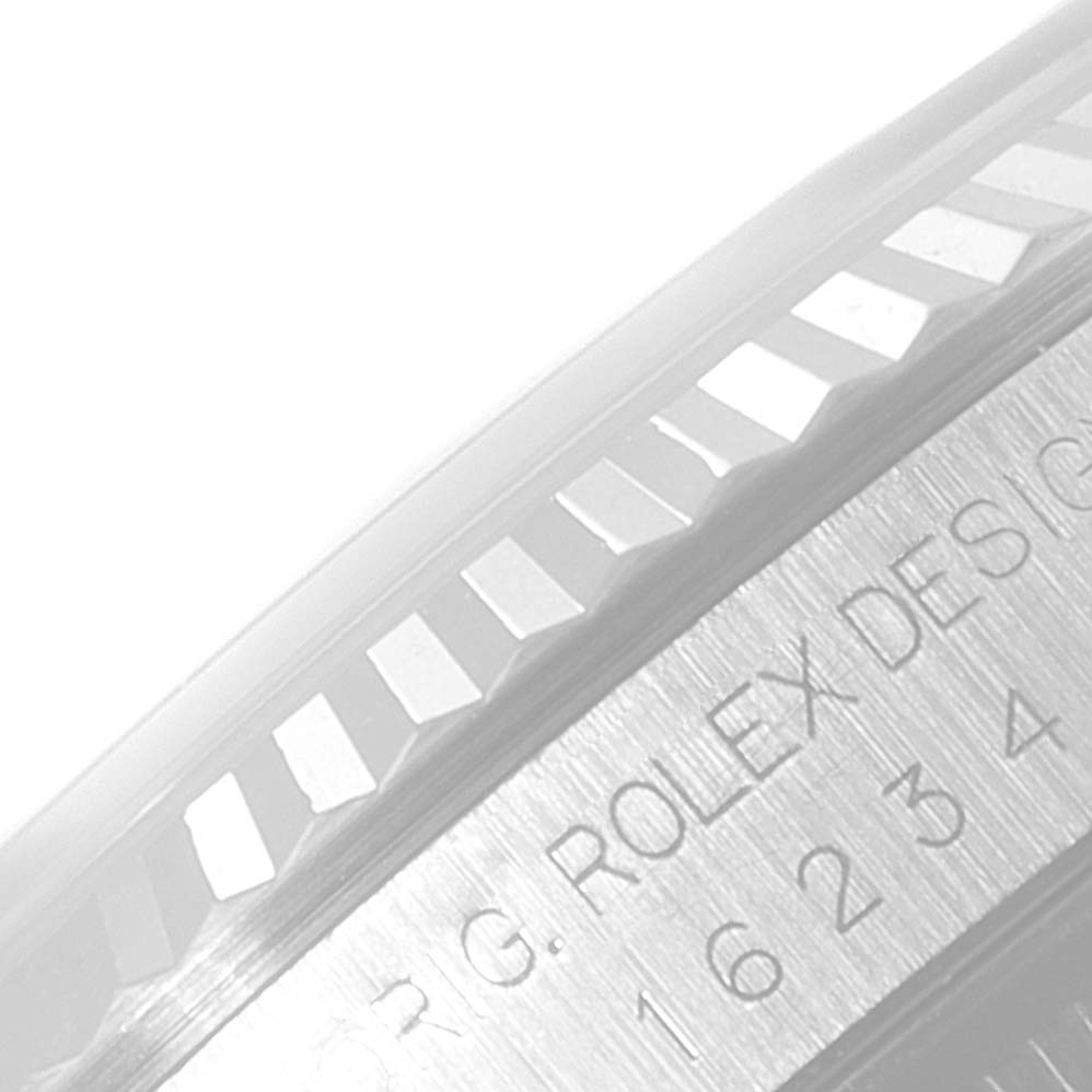 The image shows a close-up view of the fluted bezel and part of the engraved side of a Rolex Datejust 16234 Men's Stainless Steel Silver Dial 16234 Men's Stainless Steel Silver Dial watch.