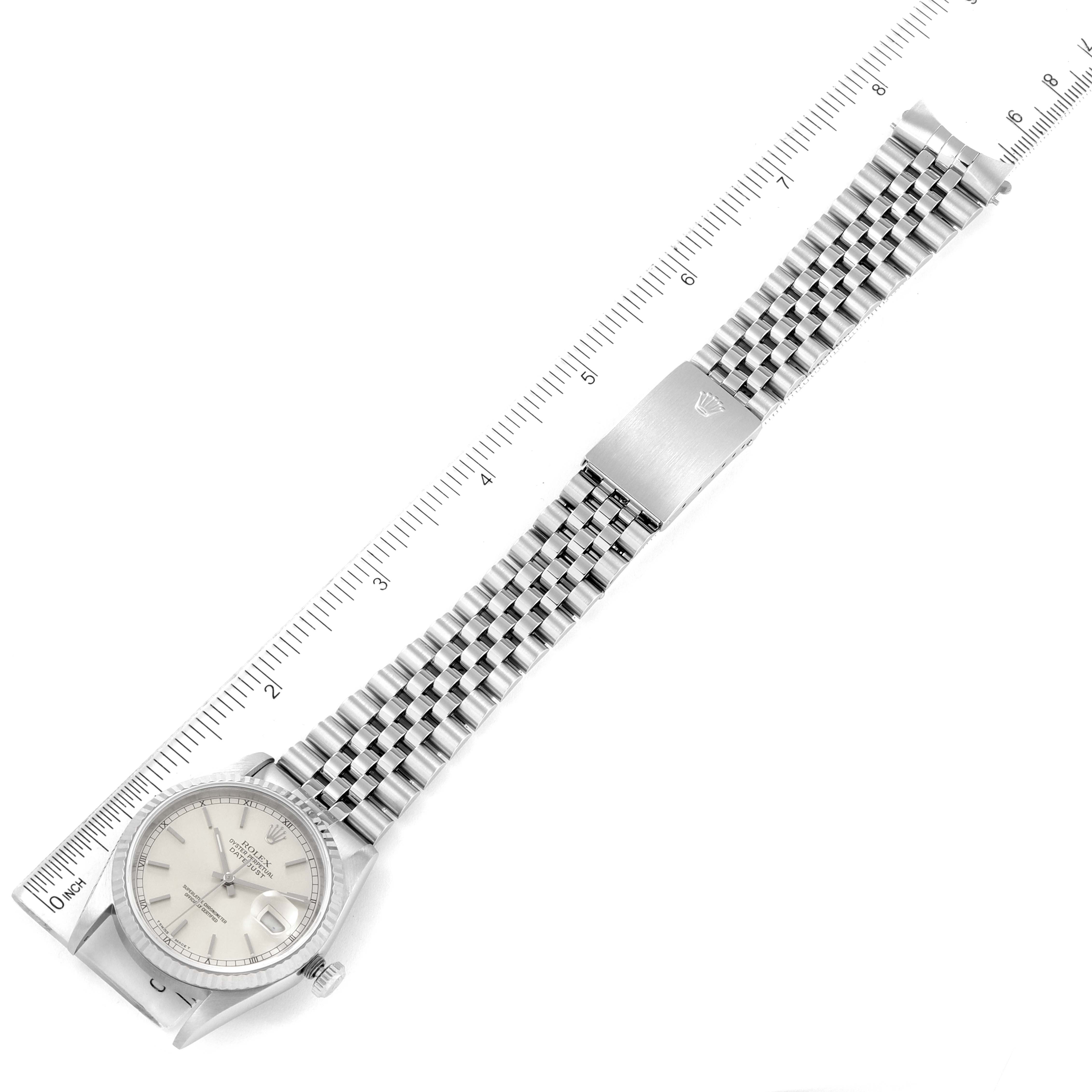 The Rolex Datejust 16234 Men's Stainless Steel Silver Dial 16234 Men's Stainless Steel Silver Dial watch is shown at a top-down angle, displaying its face, bracelet, and clasp alongside a measuring scale.