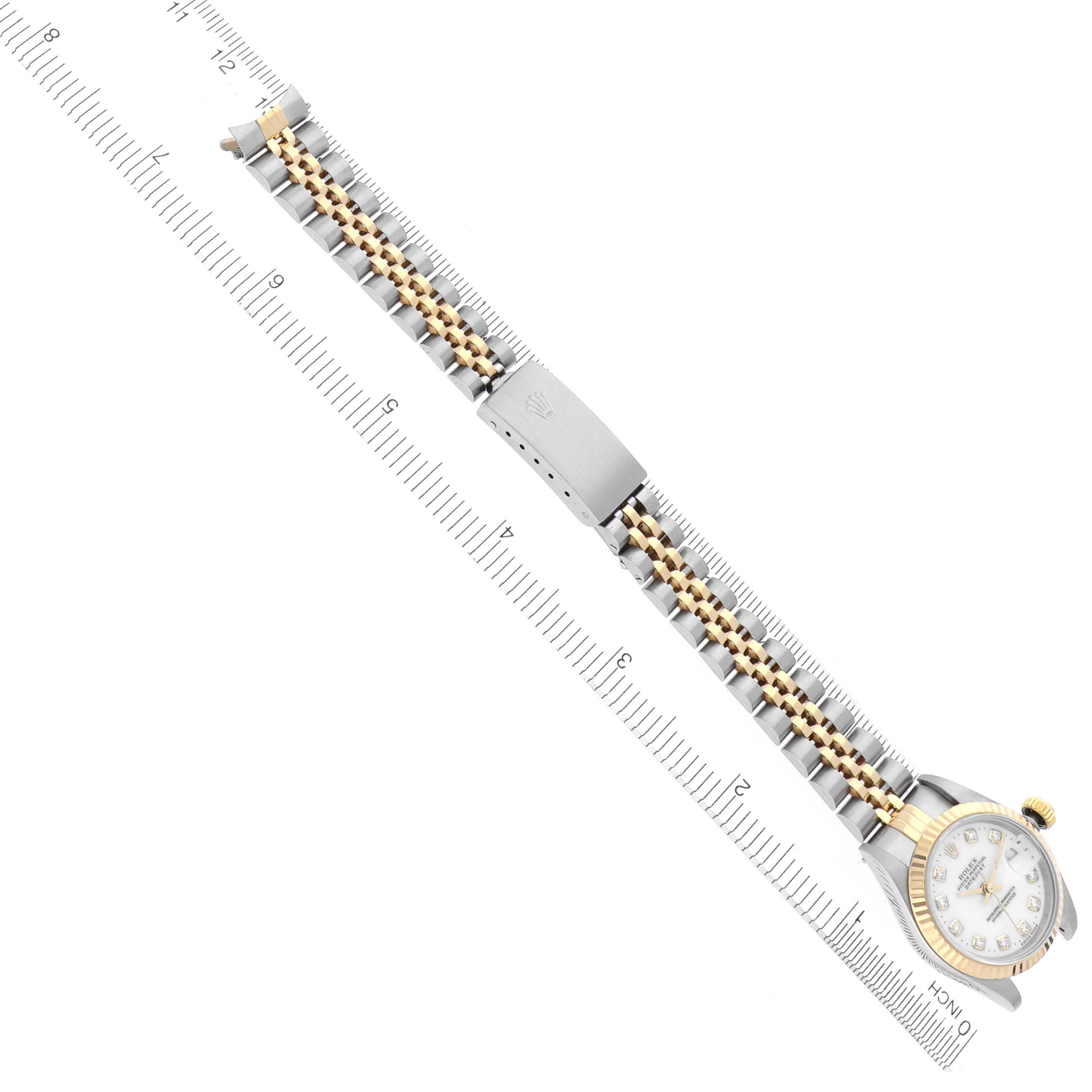 The Rolex Datejust 69173 Women's Steel and Gold (two tone) White Dial 69173 Women's Steel and Gold (two tone) White Dial watch is shown from a top-down angle, highlighting its bracelet and clasp alongside a ruler for scale.
