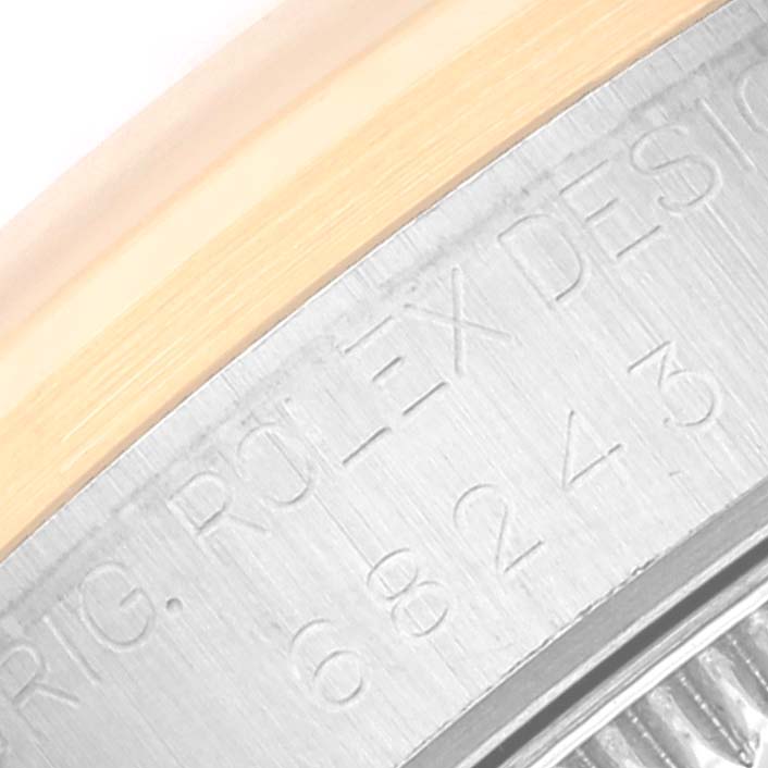 This close-up shows the engraved text on the metal case side of a Mid-Size Rolex watch.