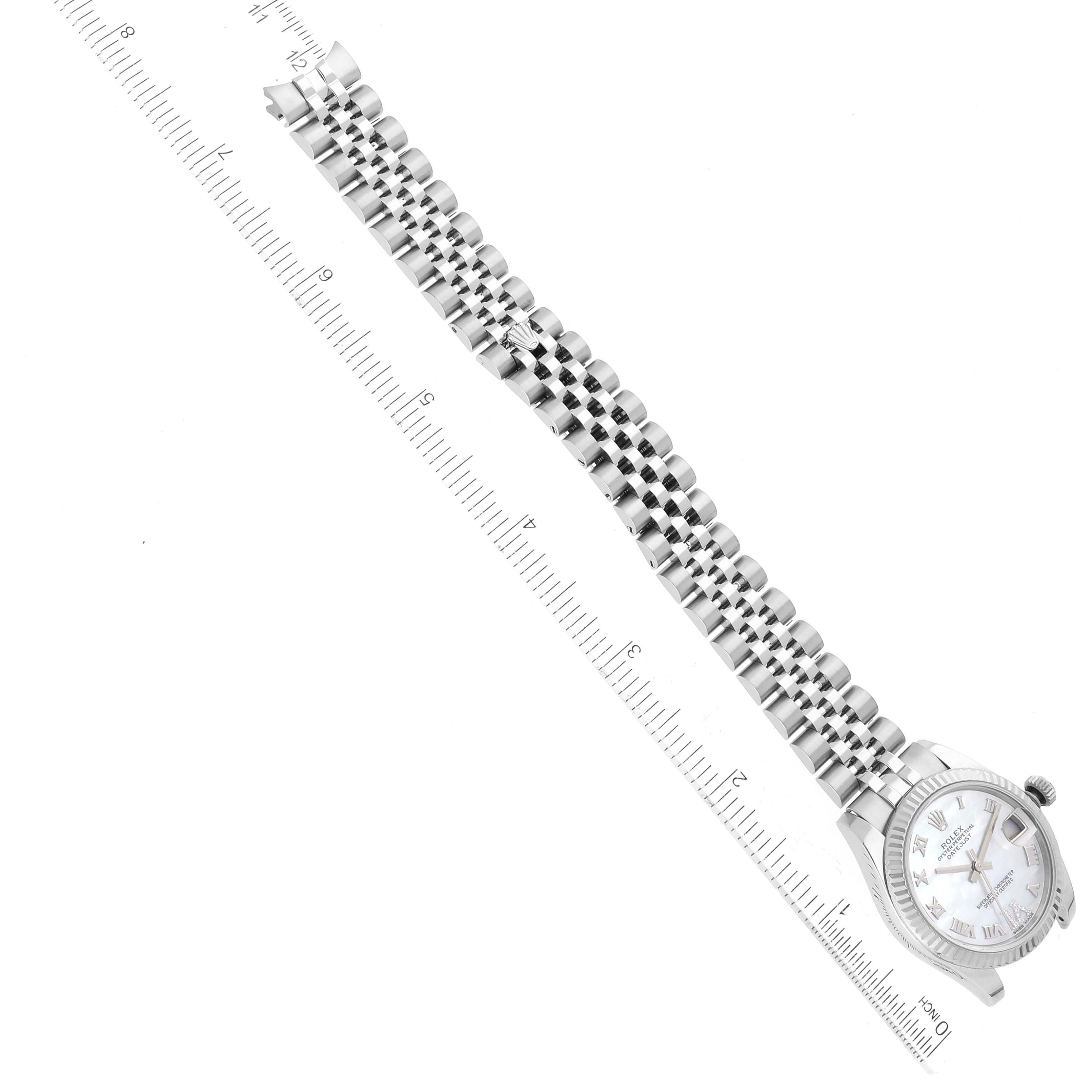 The image shows a top-down view of a Mid-Size Rolex watch with a focus on its bracelet and dial alongside a ruler for scale.